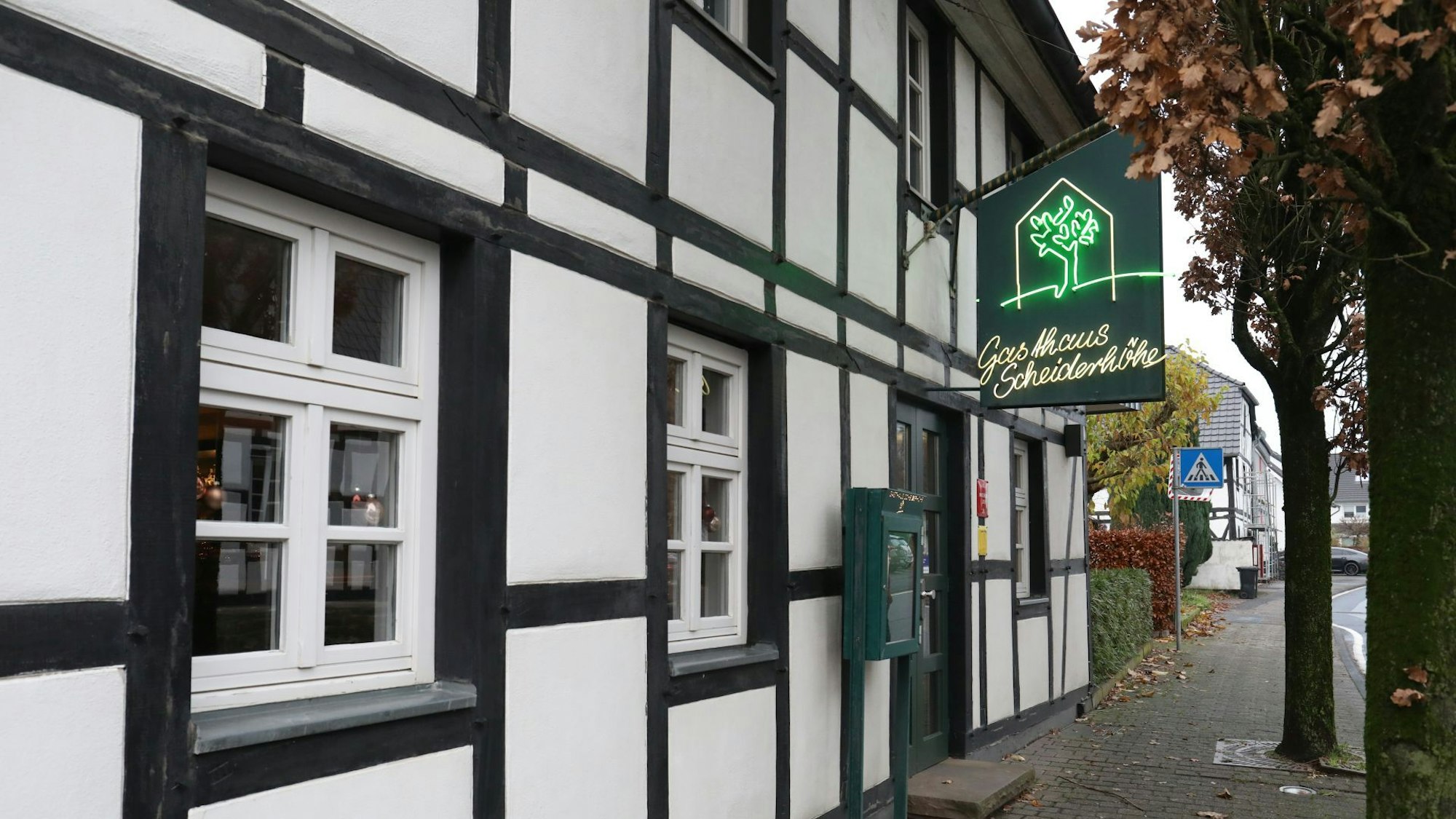 Blick auf das Gasthaus Scheiderhöhe im Lohmar mit historischem Fachwerk und grünem Werbeschild.