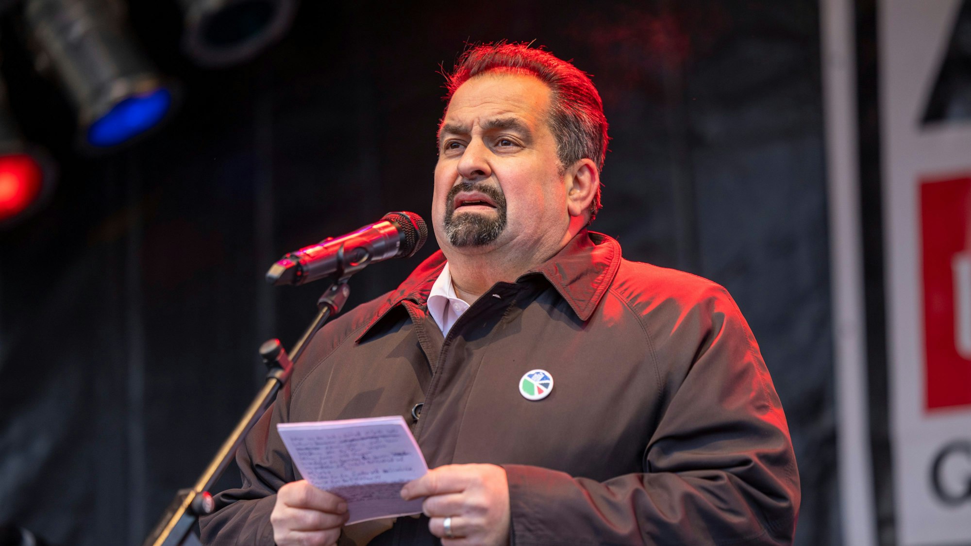 Als Sticker trug Aiman Mazyek das umstrittene Logo der Kundgebung, das die palästinensische Flagge mit dem Friedenszeichen kombiniert.