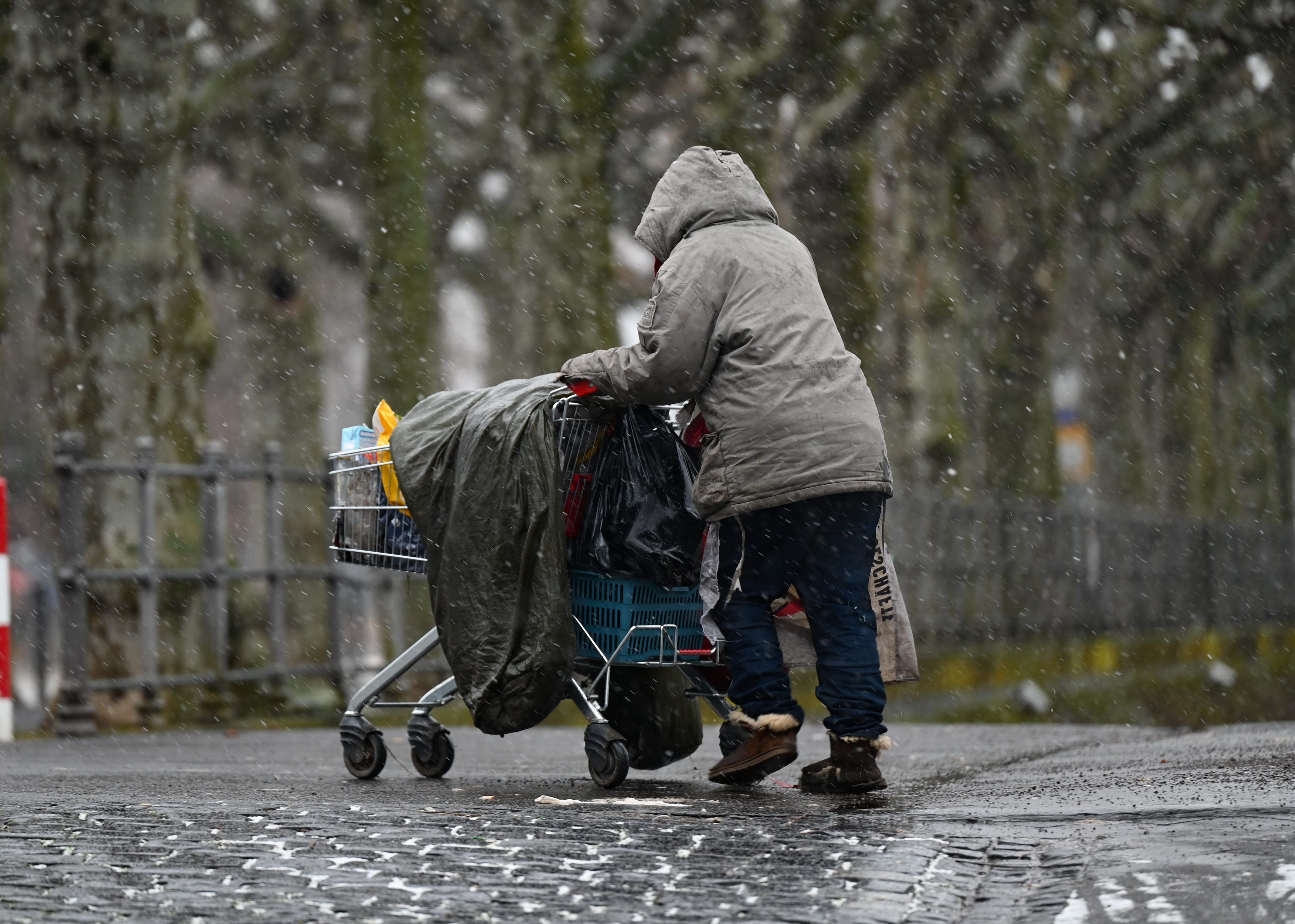 ARCHIV - 27.01.2021, Hessen, Frankfurt/Main: Eine obdachlose Frau schiebt ihr Hab und Gut in einem Einkaufswagen. In den Notunterkünften der Berliner Kältehilfe für Obdachlose herrscht Platzmangel. (zu dpa: «Platzmangel in Berliner Notunterkünften für Obdachlose») Foto: Arne Dedert/dpa +++ dpa-Bildfunk +++
