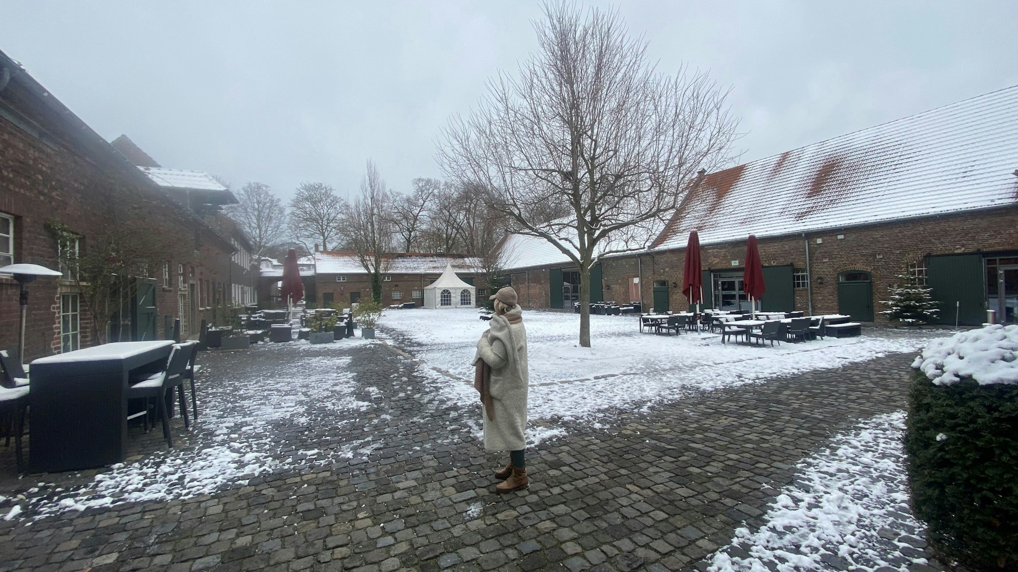 Der Innenhof eines großen Gutshofs ist zu sehen.