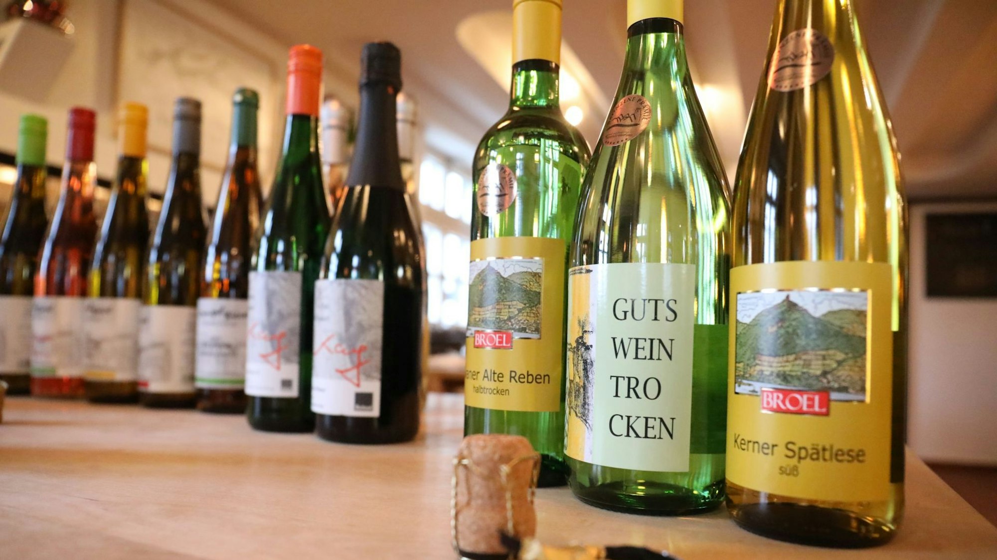 Weinflaschen stehen aufgereiht auf einem Tisch.
