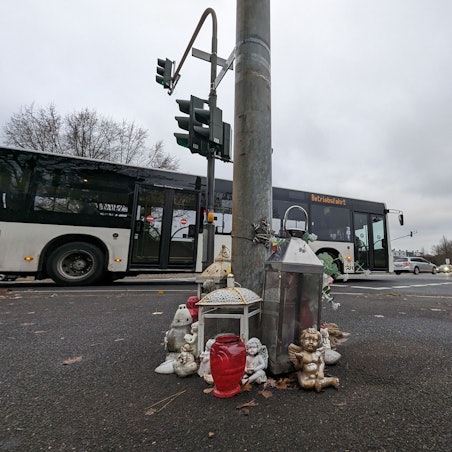 Zu sehen ist die Unfall-Kreuzung, an der Menschen Engelsfiguren und Kerzen aufgestellt haben.