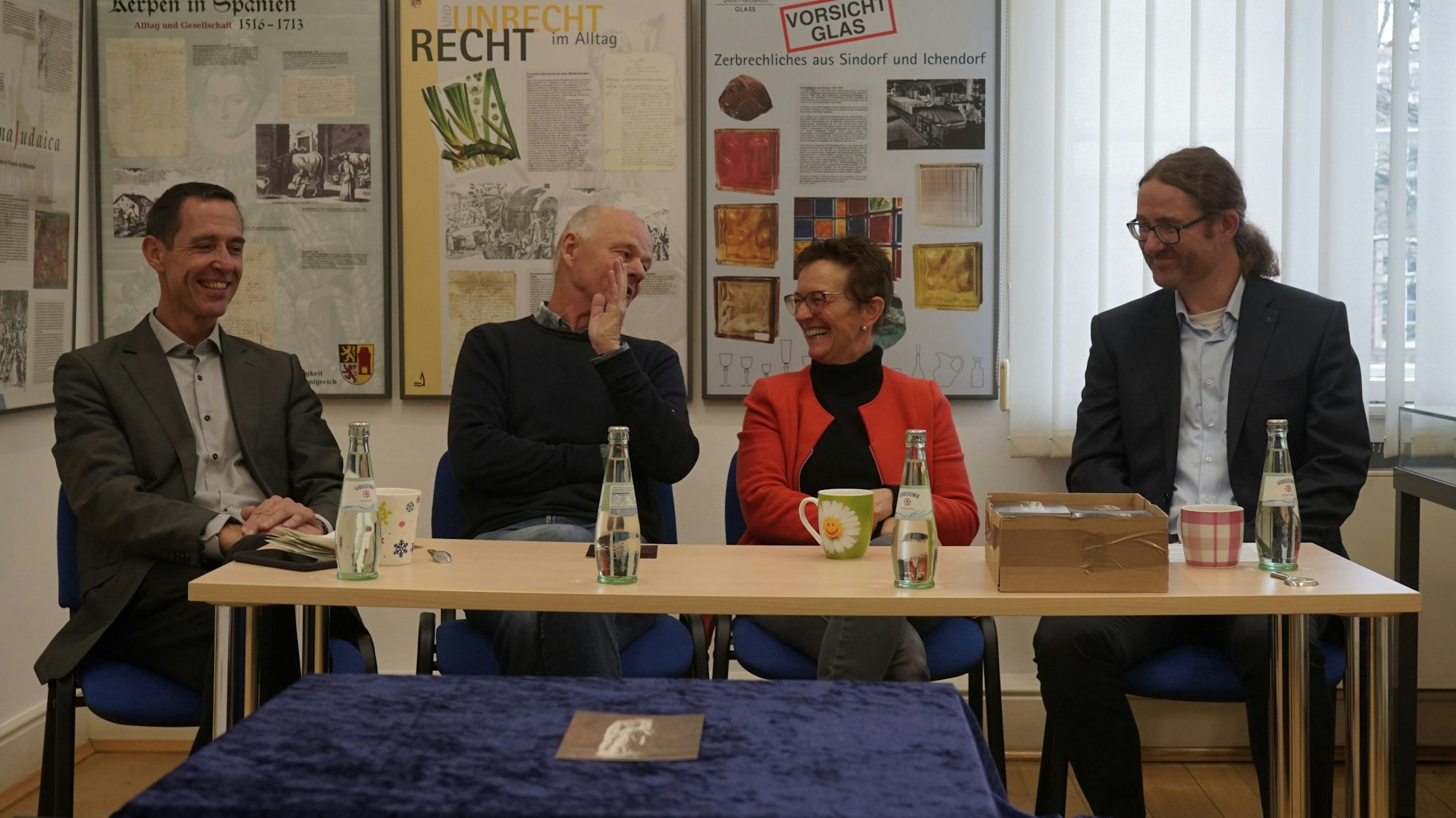 Auf dem Bild sitzen Bürgermeister Dieter Spürck, Martin Heinen (Geschäftsführer des Grabungsunternehmens Arthemus), Stadtarchivarin Susanne Harke-Schmidt und Martin Grünewald (LVR-Amt für Bodendenkmalpflege) an einem Tisch im Haus für Kunst und Geschichte.