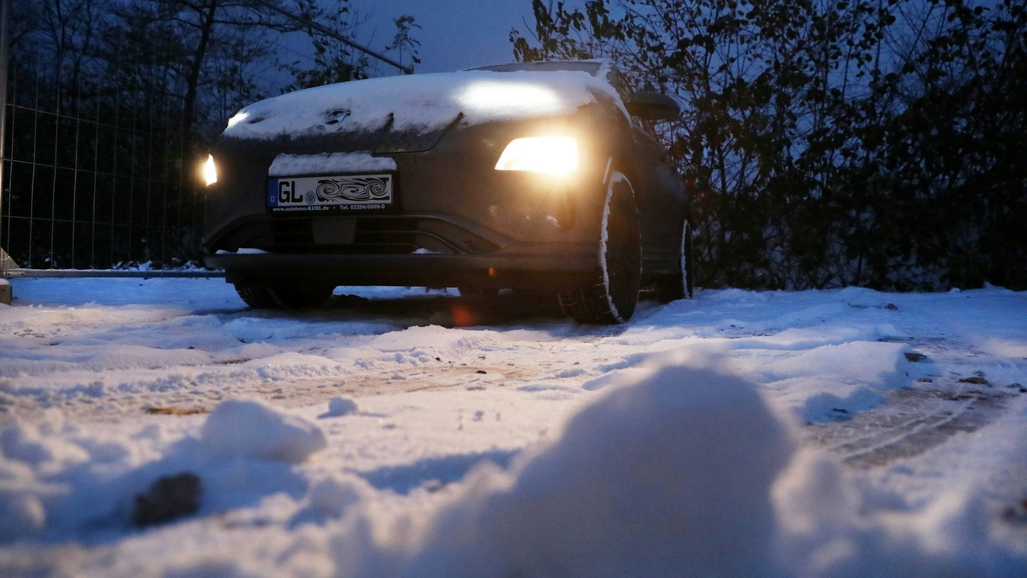 Ein Auto steht auf einem verschneiten Parkplatz.