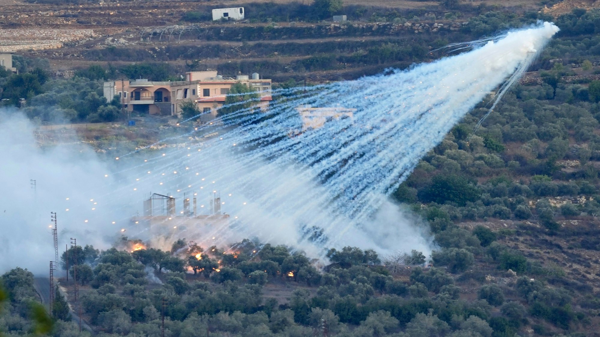 ARCHIV - 15.10.2023, Libanon, Al-Bustan: Eine Granate der israelischen Artillerie explodiert über einem Haus in einem libanesischen Grenzdorf. Neun Raketen sind nach israelischen Militärangaben am Sonntag (15.10.2023) vom Libanon aus auf Israel abgefeuert worden. Die Raketenabwehr habe fünf der Geschosse abgefangen. Foto: Hussein Malla/AP/dpa +++ dpa-Bildfunk +++