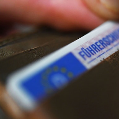 Eine Frau nimmt einen Führerschein im EU-Scheckkartenformat aus ihrem Geldbeutel.