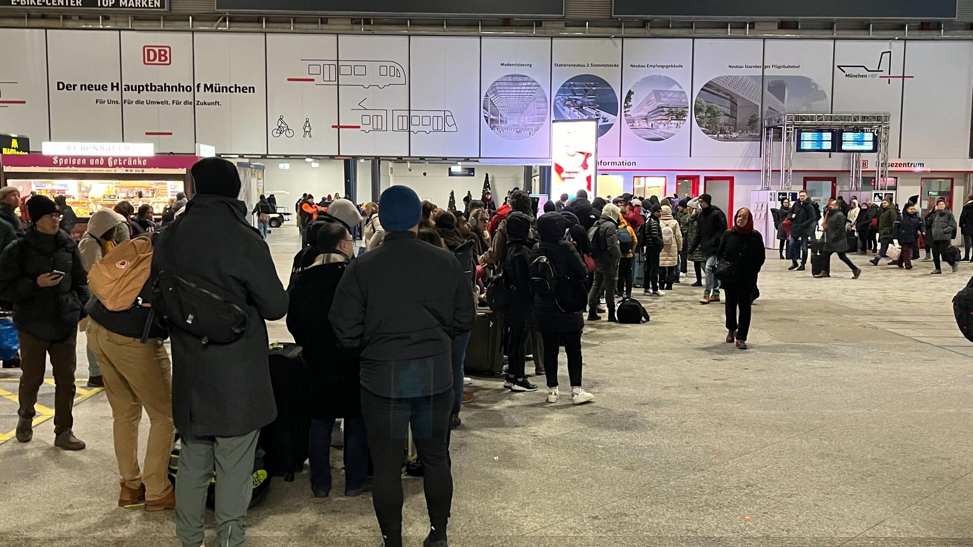 Menschen stehen in der Halle am Hauptbahnhof Schlange.