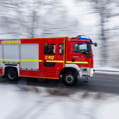 Feuerwehrfahrzeug auf verschneiter Straße.
