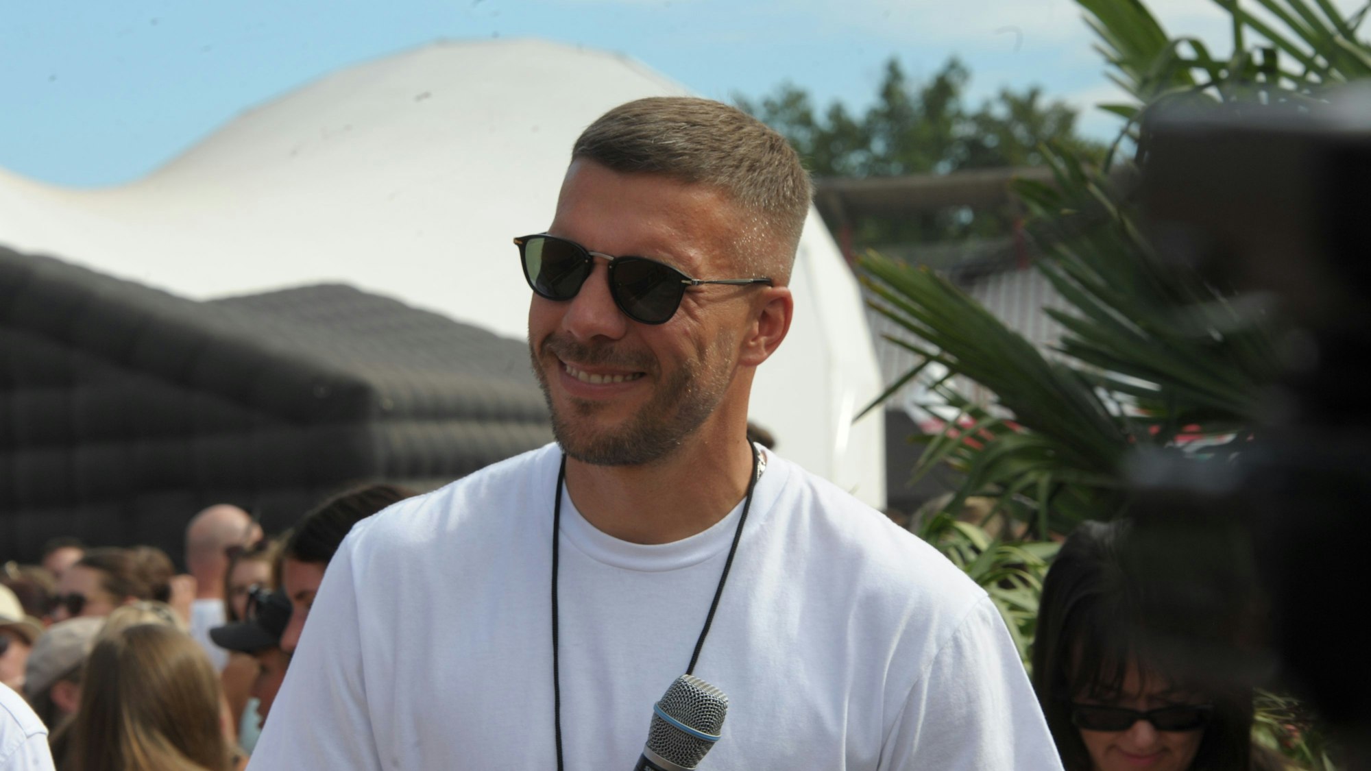 Mitorganisator Lukas Podolski lächelt 2023 auf dem „Glücksgefühle“-Festival am Hockenheimring. (Archivbild)