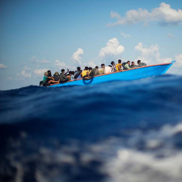 ARCHIV - 11.08.2022, Italien, ---: Migranten sitzen in einem Holzboot im Mittelmeer nahe der Insel Lampedusa. (zu dpa «Erneut Hunderte Bootsmigranten auf Lampedusa gelandet») Foto: Francisco Seco/AP/dpa +++ dpa-Bildfunk +++