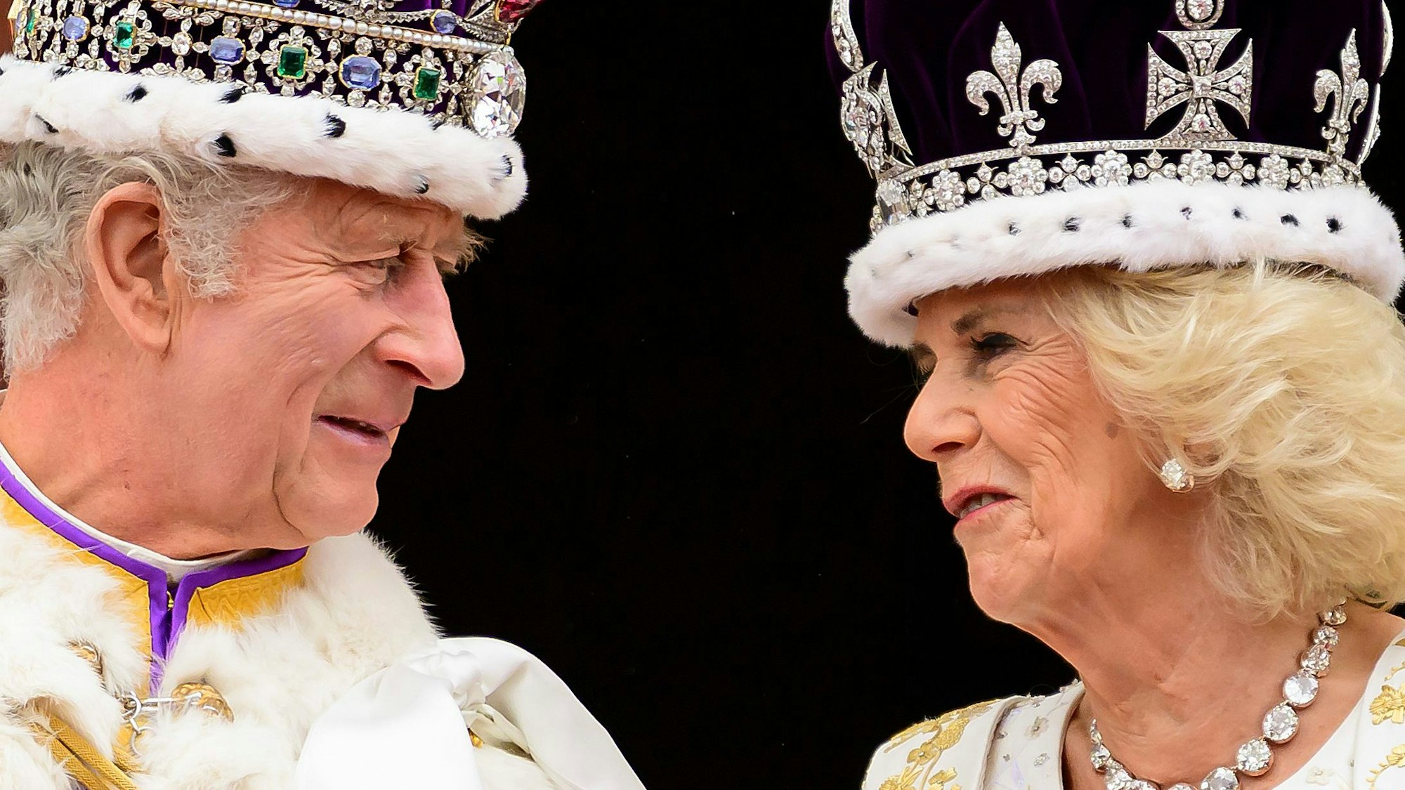 König Charles III. und Königin Camilla sehen sich an, als sie nach ihrer Krönung auf dem Balkon des Buckingham-Palastes stehen.