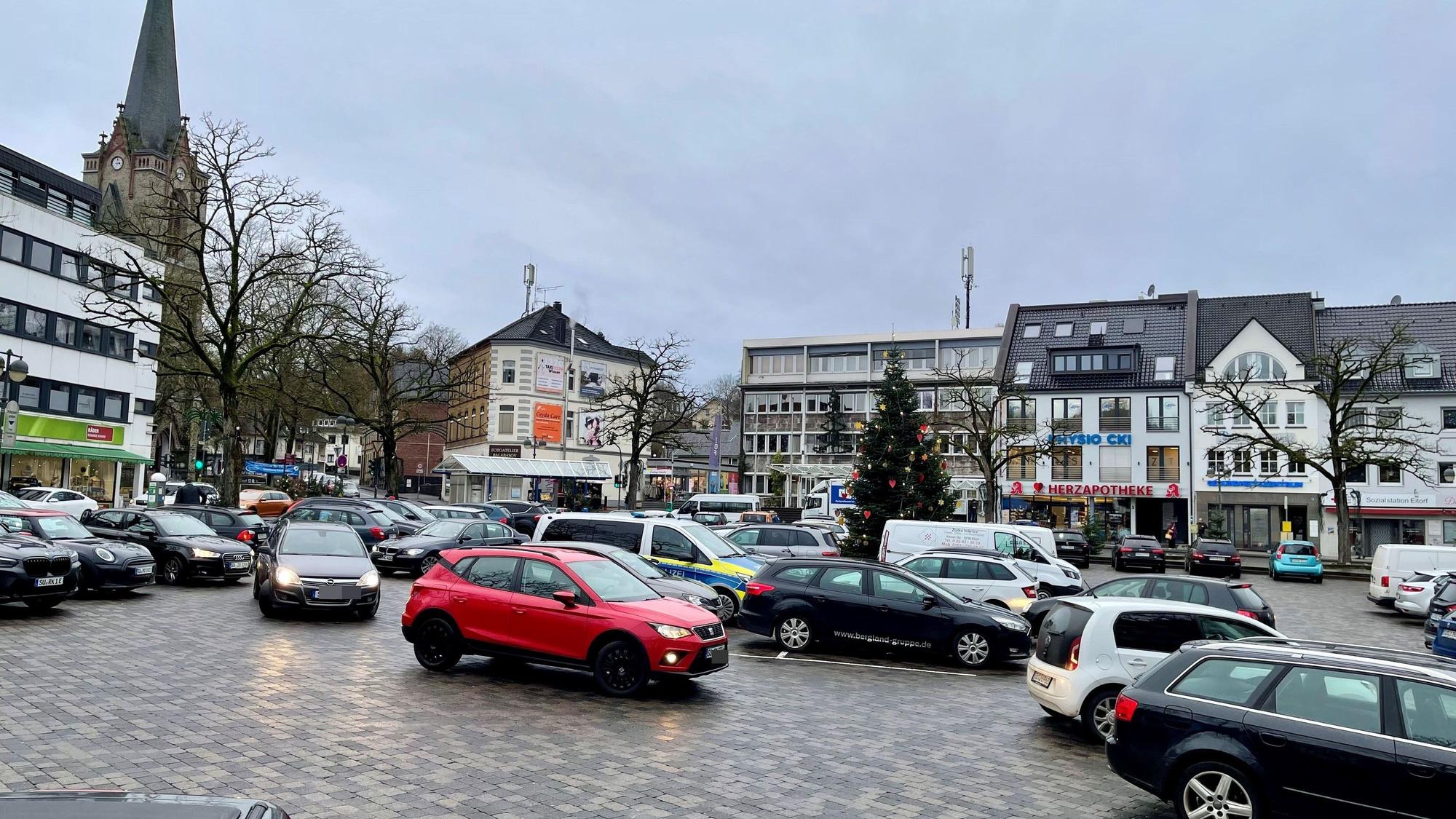 Eine gepflasterte Fläche, auf der Autos parken.