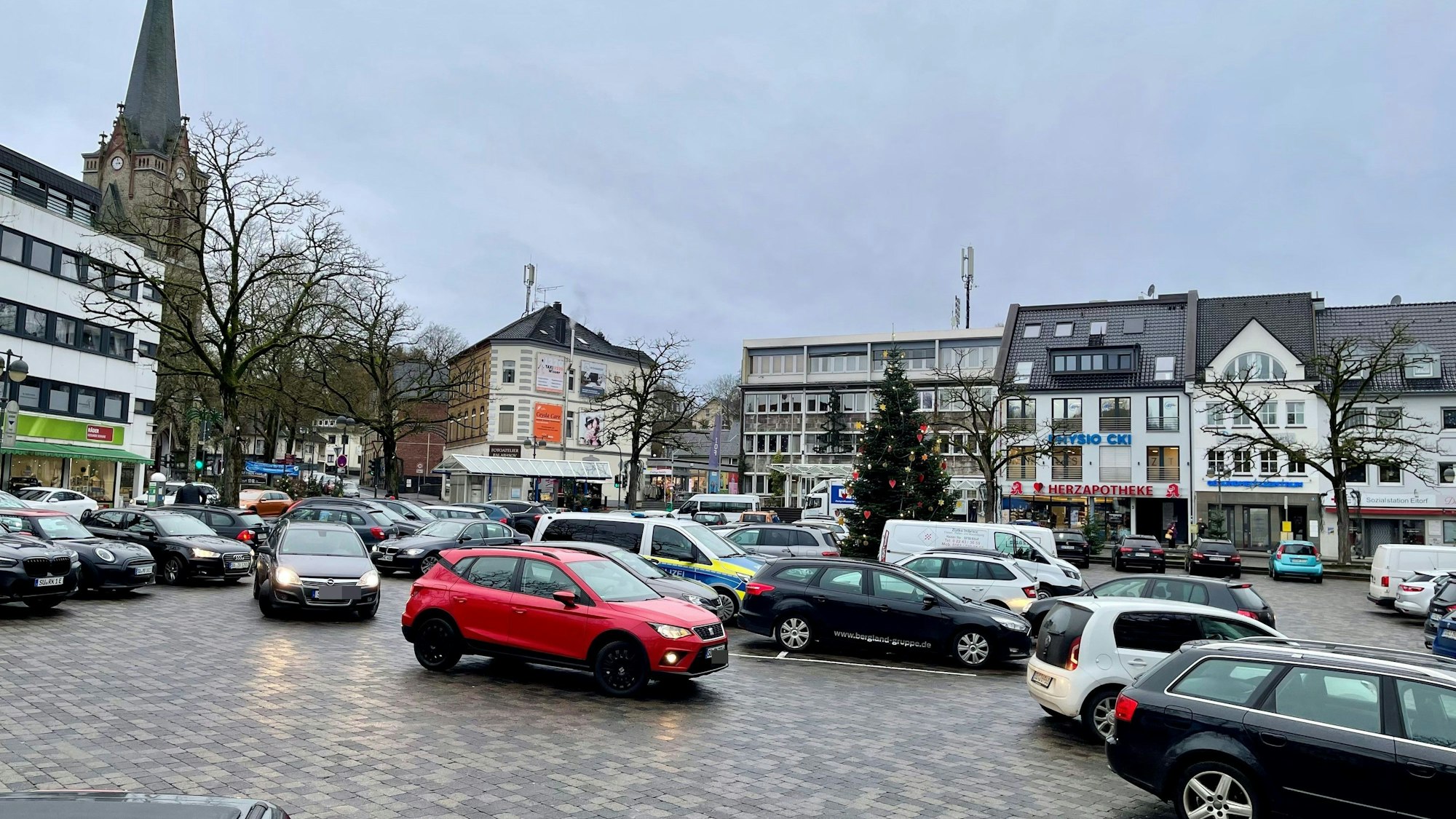 Eine gepflasterte Fläche, auf der Autos parken.