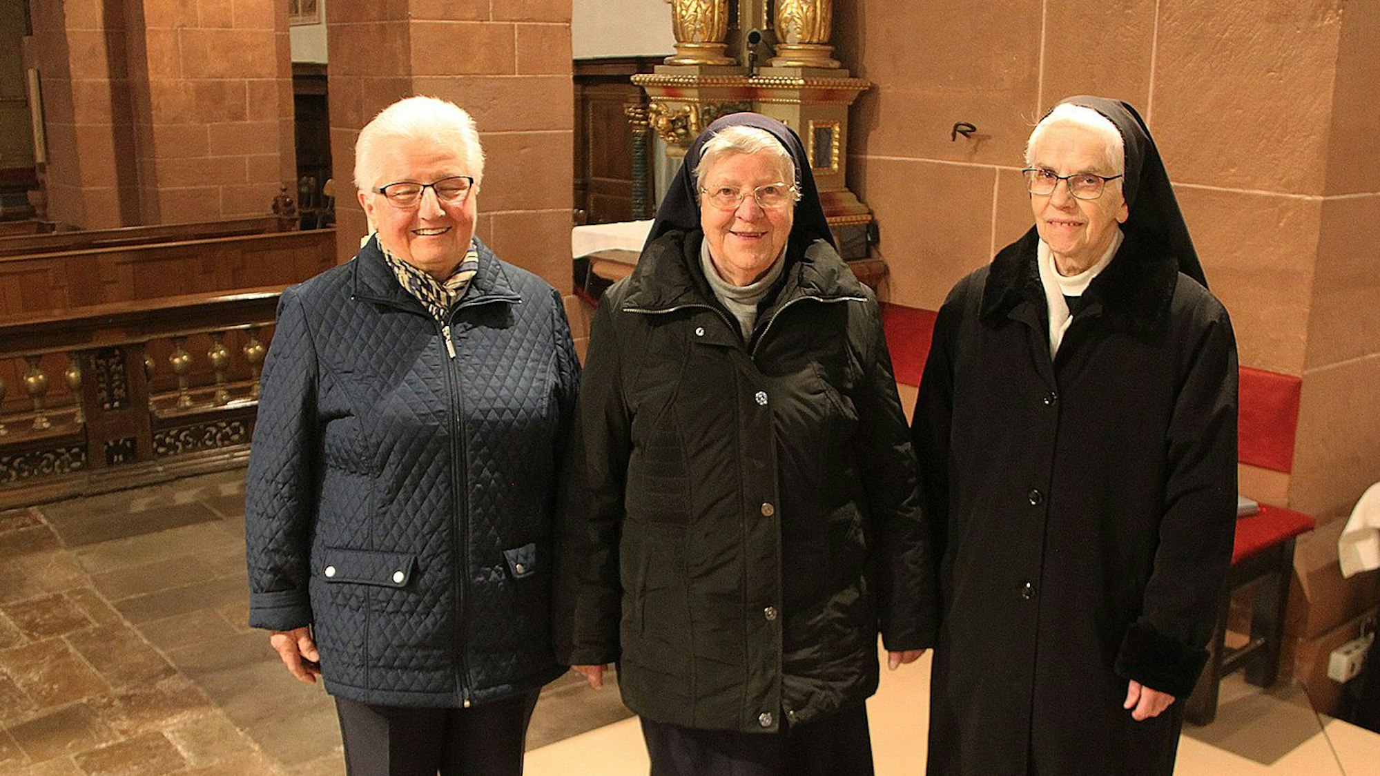 Drei Ordensschwestern der Salvatorianerinnen stehen in der Basilika in Steinfeld.