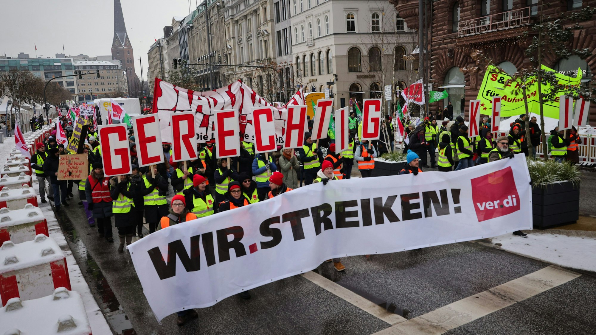 Teilnehmerinnen und Teilnehmer eines Demonstrationszuges der Gewerkschaft Verdi laufen am Jungfernstieg zur Finanzbehörde.