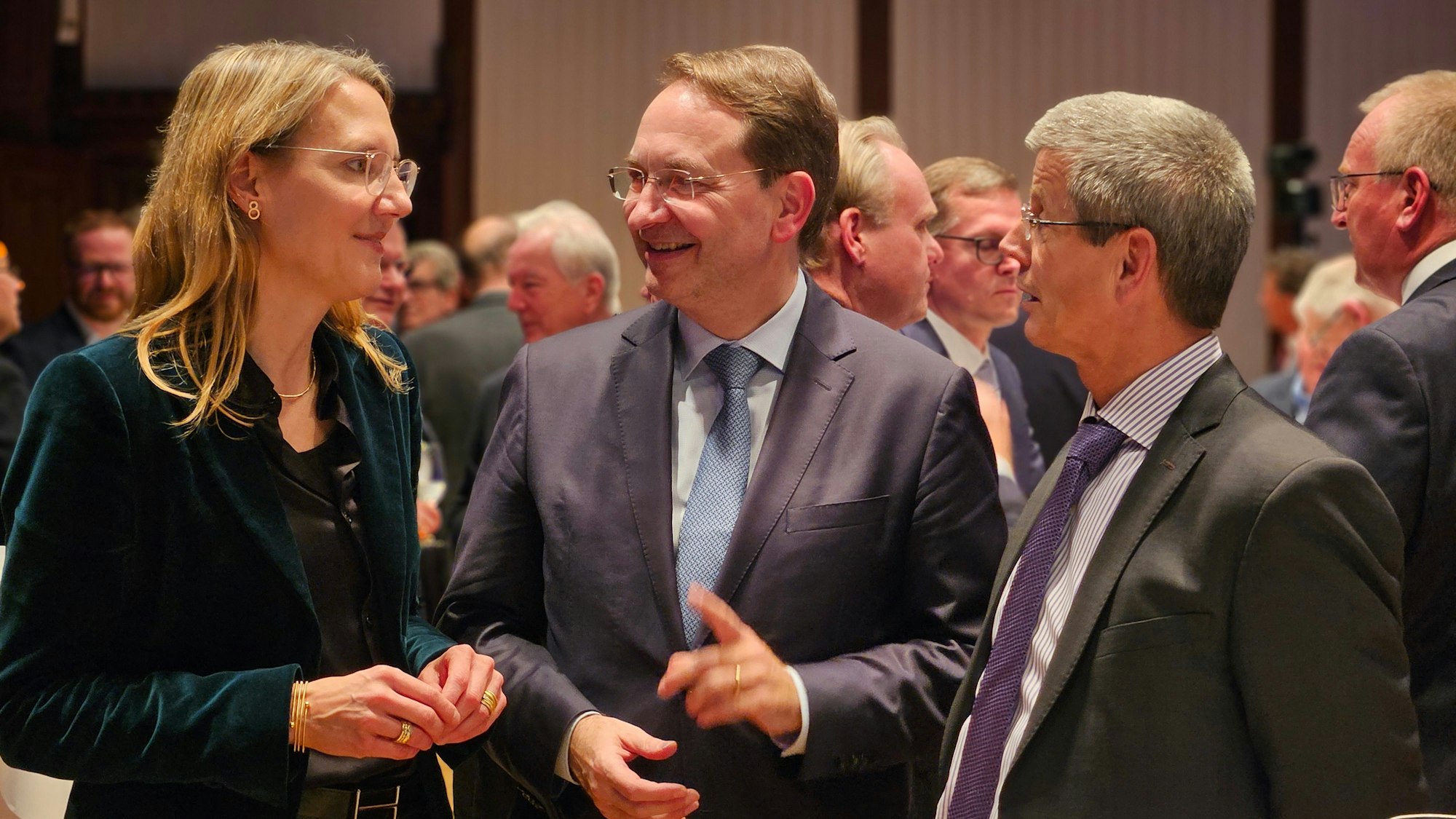 Eine Frau und zwei Männer unterhalten sich.