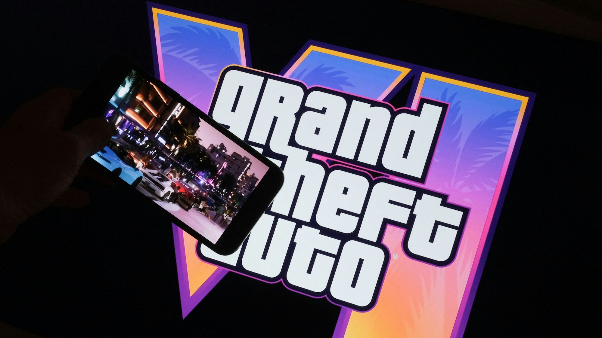 This illustration photo created in Los Angeles, December 4, 2023, shows Rockstar Games Grand Theft Auto VI trailer played on a screen in front of the game title. The first trailer for "Grand Theft Auto VI" was officially released ahead of schedule December 4, 2023 due to a leak, touting a 2025 release for the next chapter of the massively successful video game franchise. (Photo by Chris DELMAS / AFP)