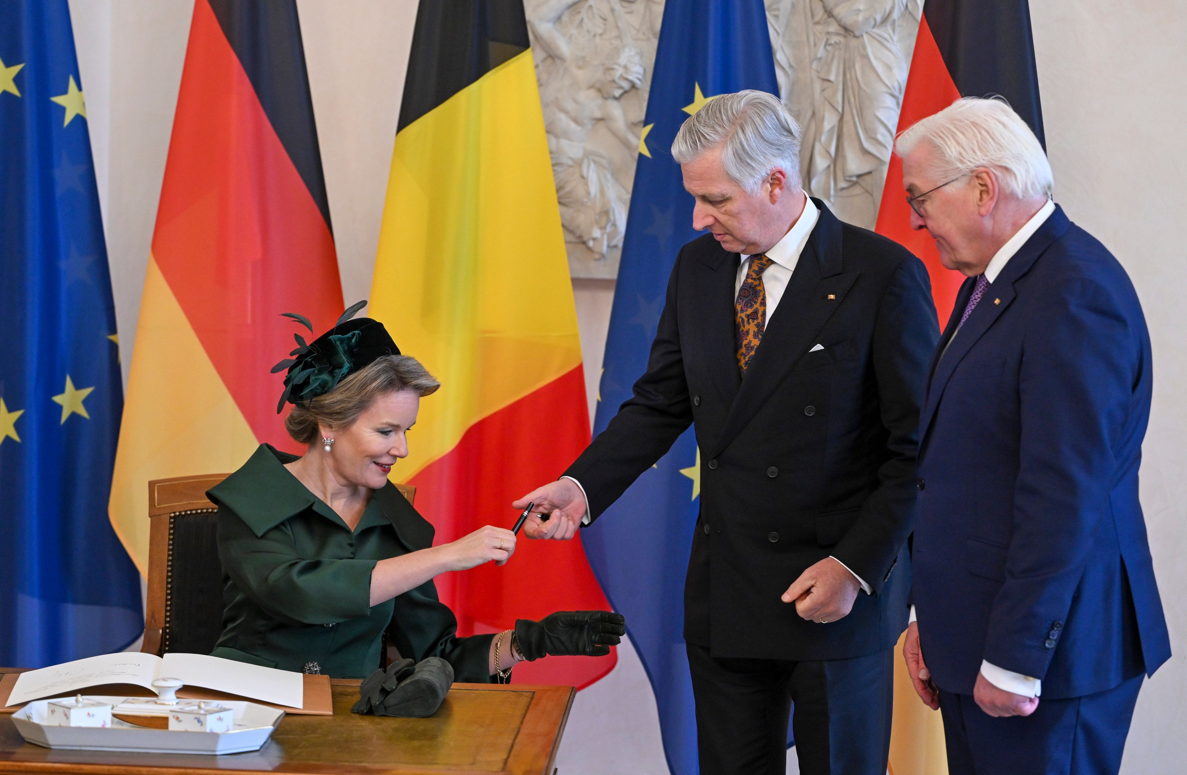 Das belgische Königspaar König Philippe (m.) und Königin Mathilde tragen sich in das Gästebuch im Schloss Bellevue ein, während Bundespräsident Frank-Walter Steinmeier neben ihnen steht.