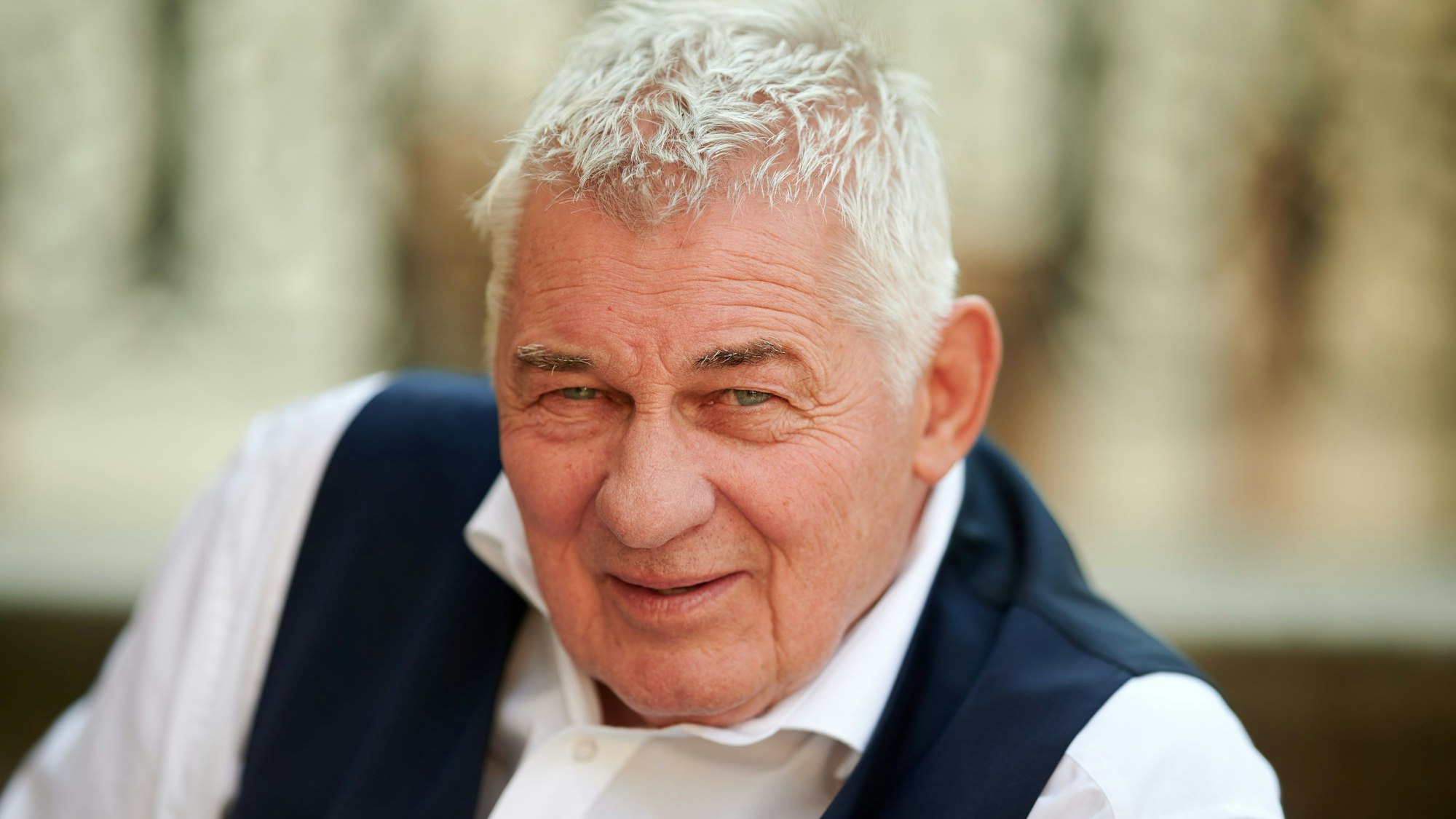 Der Schauspieler Heinz Hoenig sitzt bei einem Fototermin bei Dreharbeiten zur TVNOW Serie "Verbotene Liebe - Next Generation" auf einer Treppe.