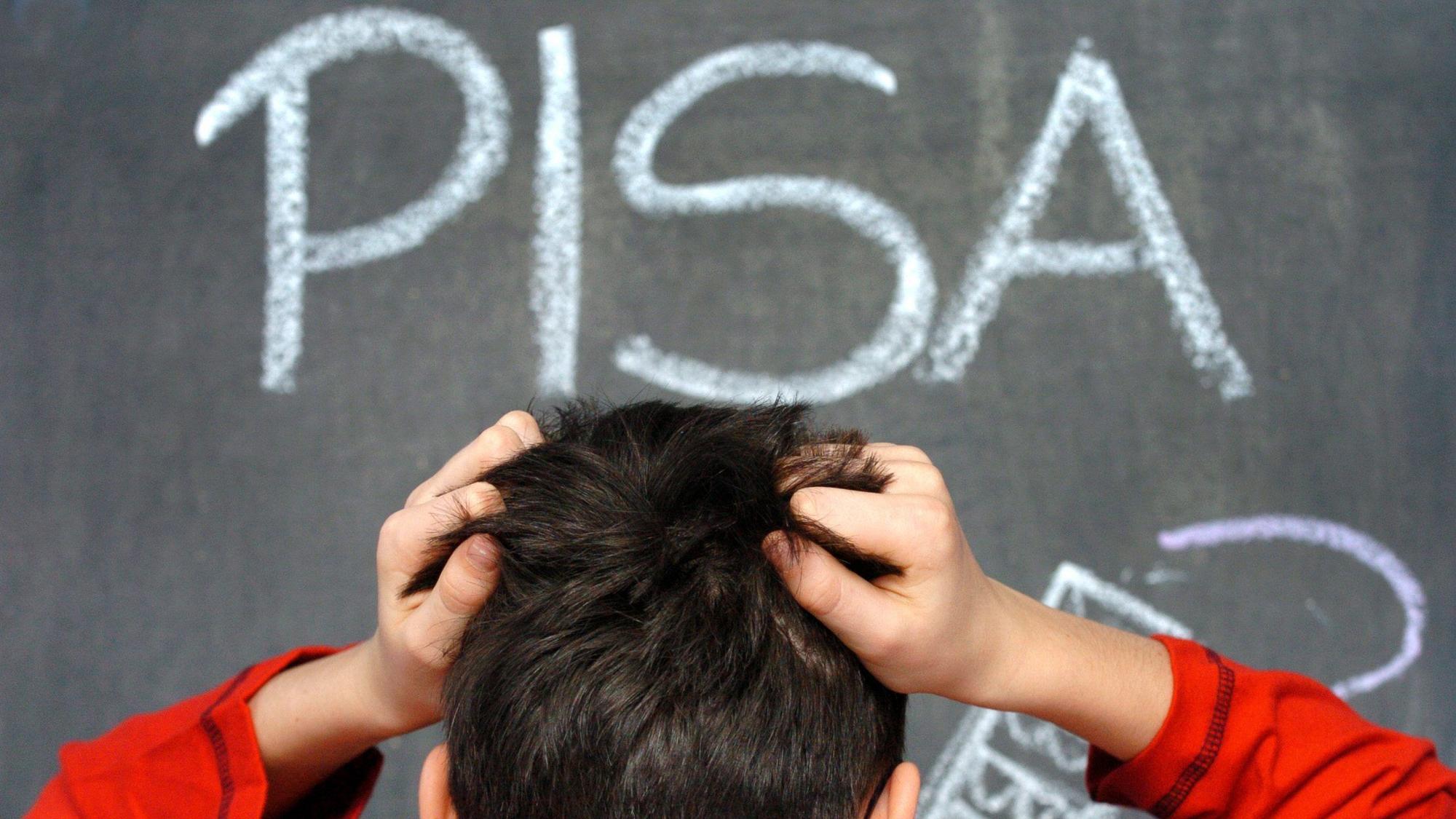 Der Schüler Arne rauft sich in Schwerin vor dem mit Kreide an eine Schultafel geschriebenen Wort PISA die Haare.
