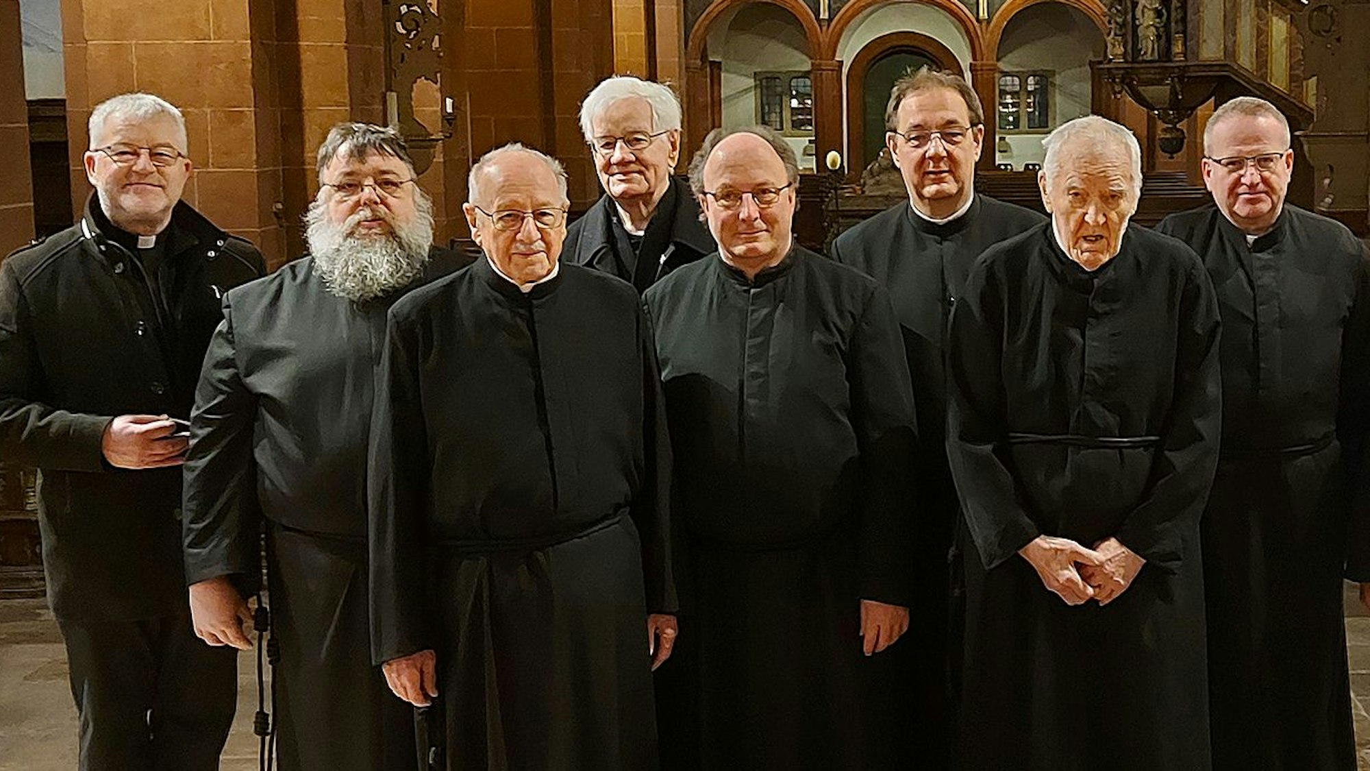 Acht Patres und Brüder der Salvatorianer stehen in der Basilika in Steinfeld.