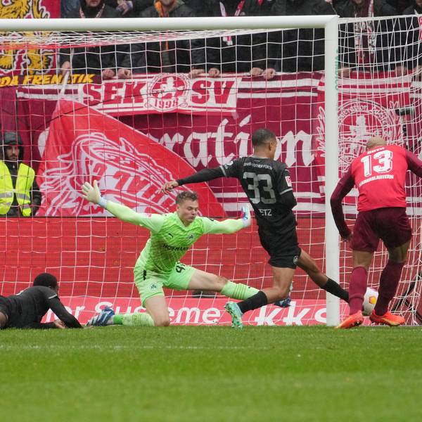 Jonas Urbig wirft sich in den Schuss eines Fußballspielers.