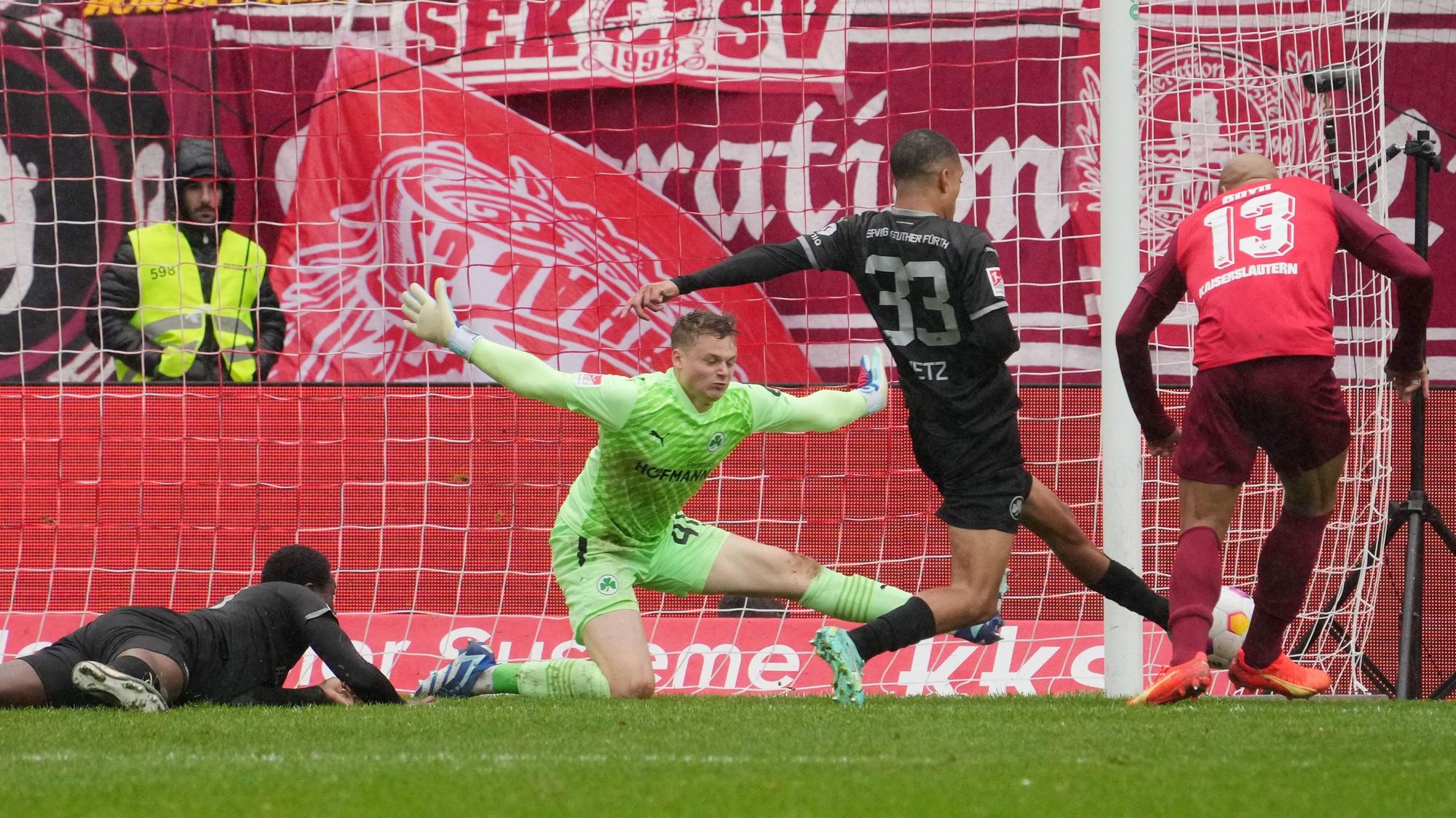 Jonas Urbig wirft sich in den Schuss eines Fußballspielers.