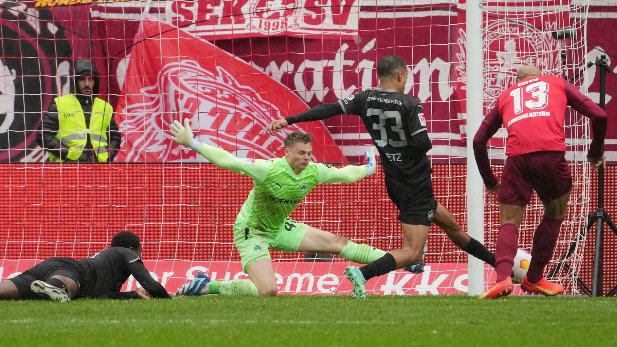 Jonas Urbig wirft sich in den Schuss eines Fußballspielers.