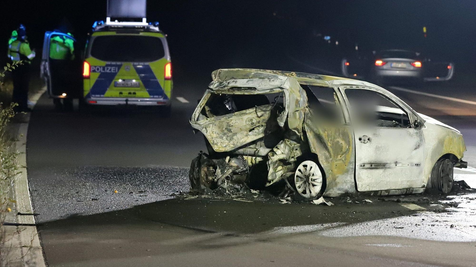 Das Bild zeigt einen ausgebrannten Kleinwagen auf der Autobahn.