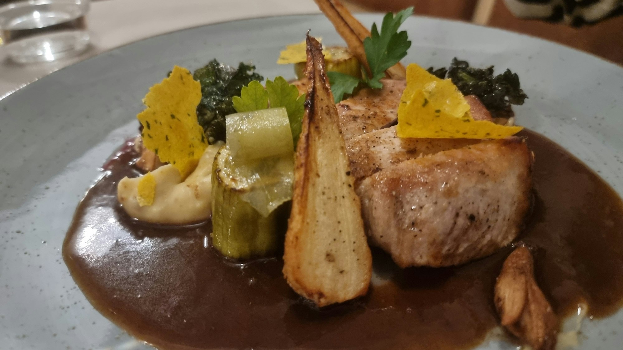 Teller mit Kolelett, Sauce und verschiedenen Gemüsen.