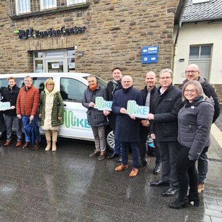 Auf dem Foto stehen Vertreter vom Kreis Euskirchen, der RVK und der Kommunen vor einem Taxibus.