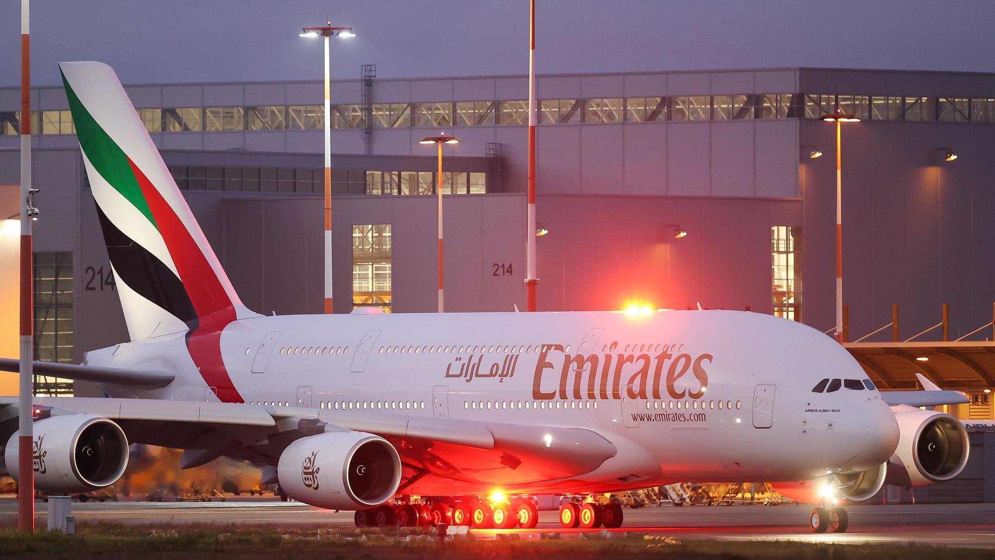 Ein Airbus A380 der arabischen Fluggesellschaft Emirates steht an einem Rollfeld vor einem roten Warnlicht. (Symbolbild)