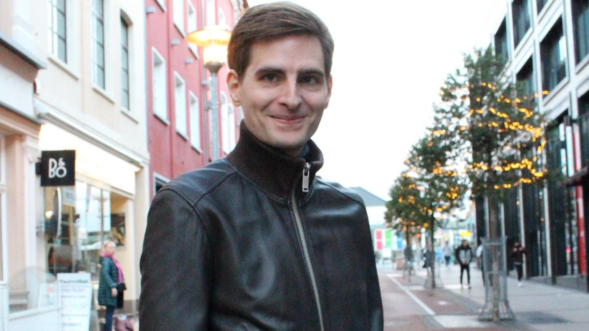 Arvid Bell steht auf der weihnachtlich geschmückten Bahnhofstraße in Euskirchen.
