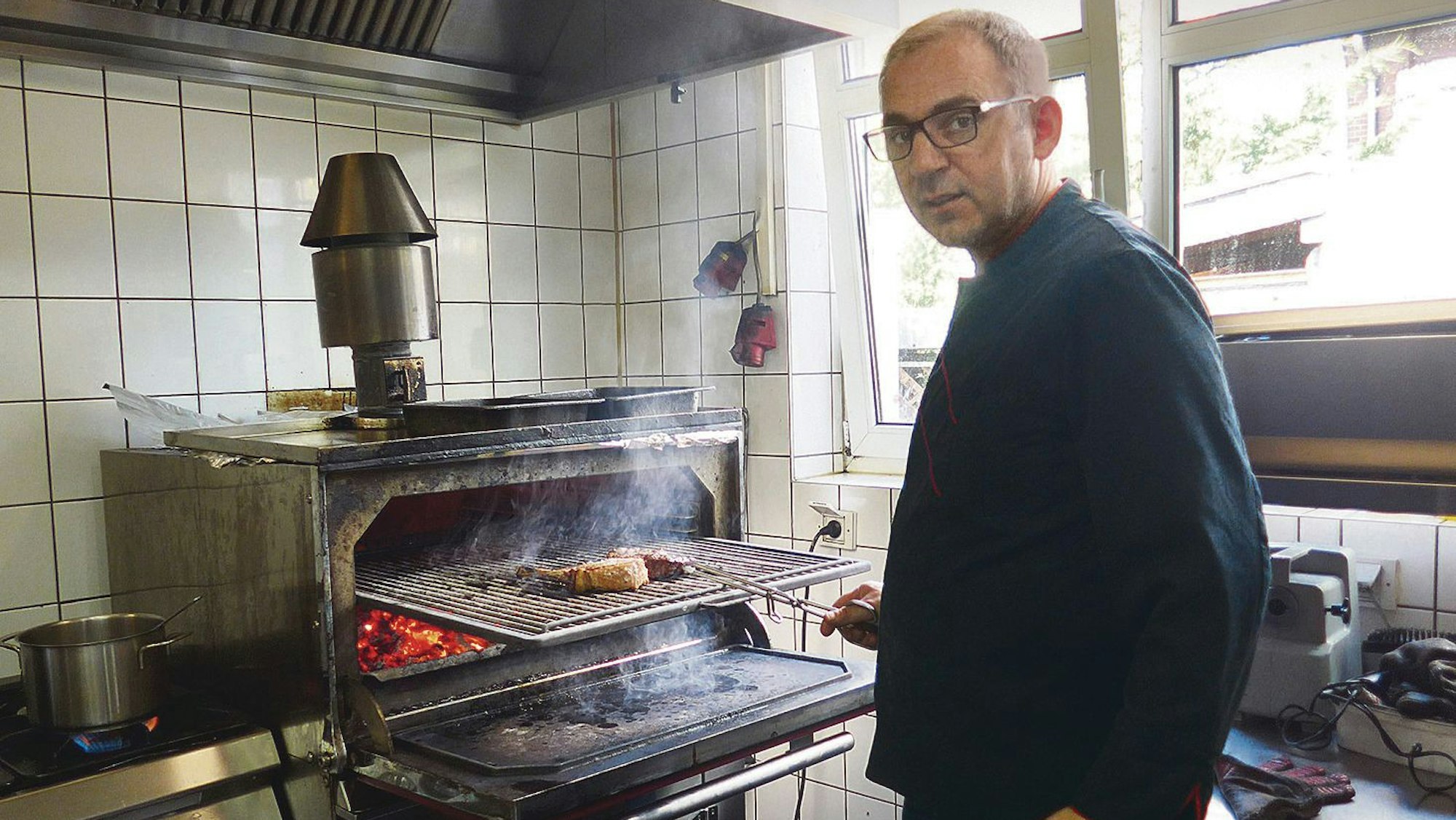 Stanislav Peraic bereitet Fleisch und Gemüse im Josper-Grill zu.