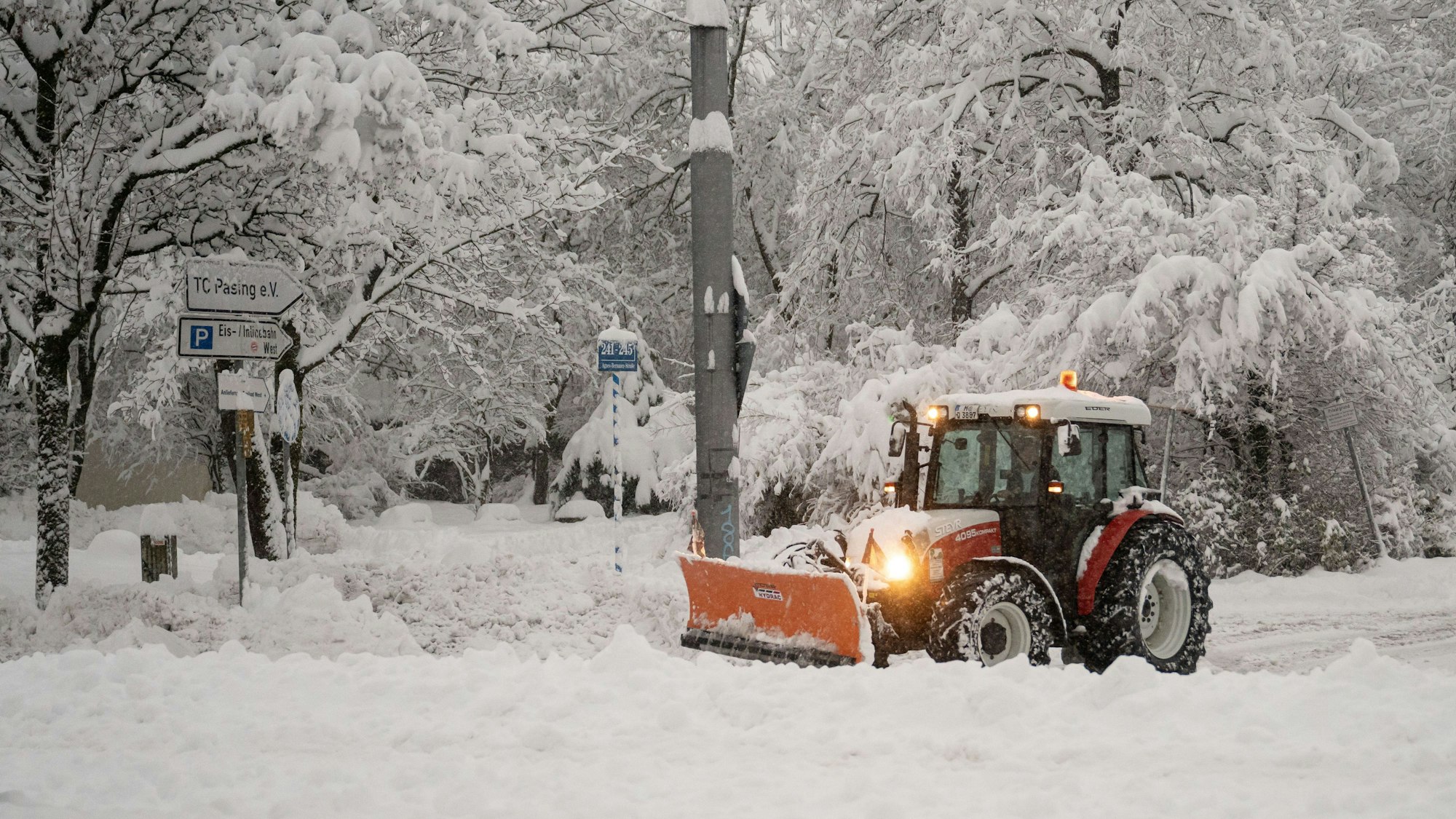 Ein Räumfahrzeug beseitigt Schneemassen auf einem Parkplatz.