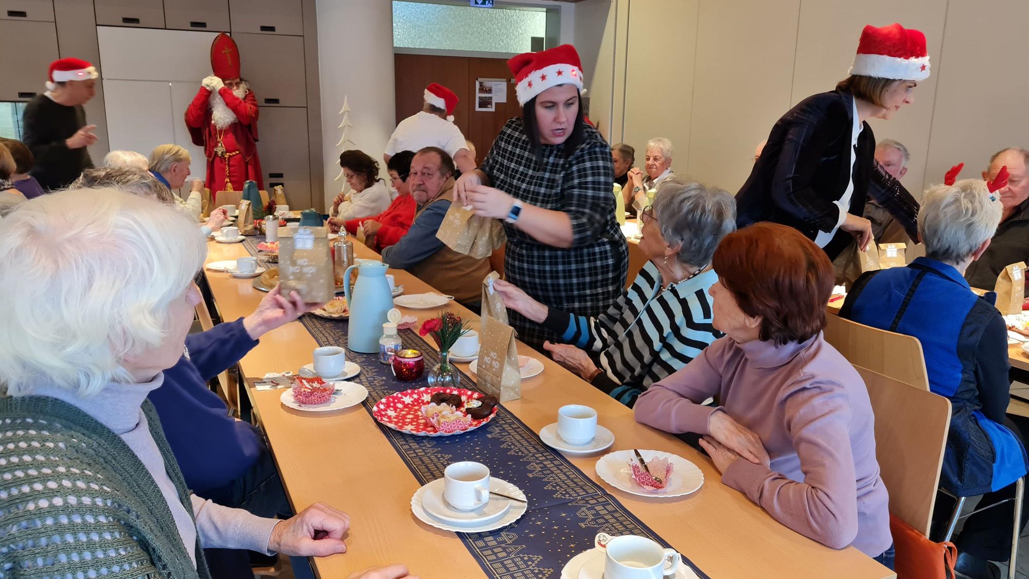 Der Nikolaus und seine Helferinnen und Helfer verteilen Geschenke beim Kaffeeklatsch.