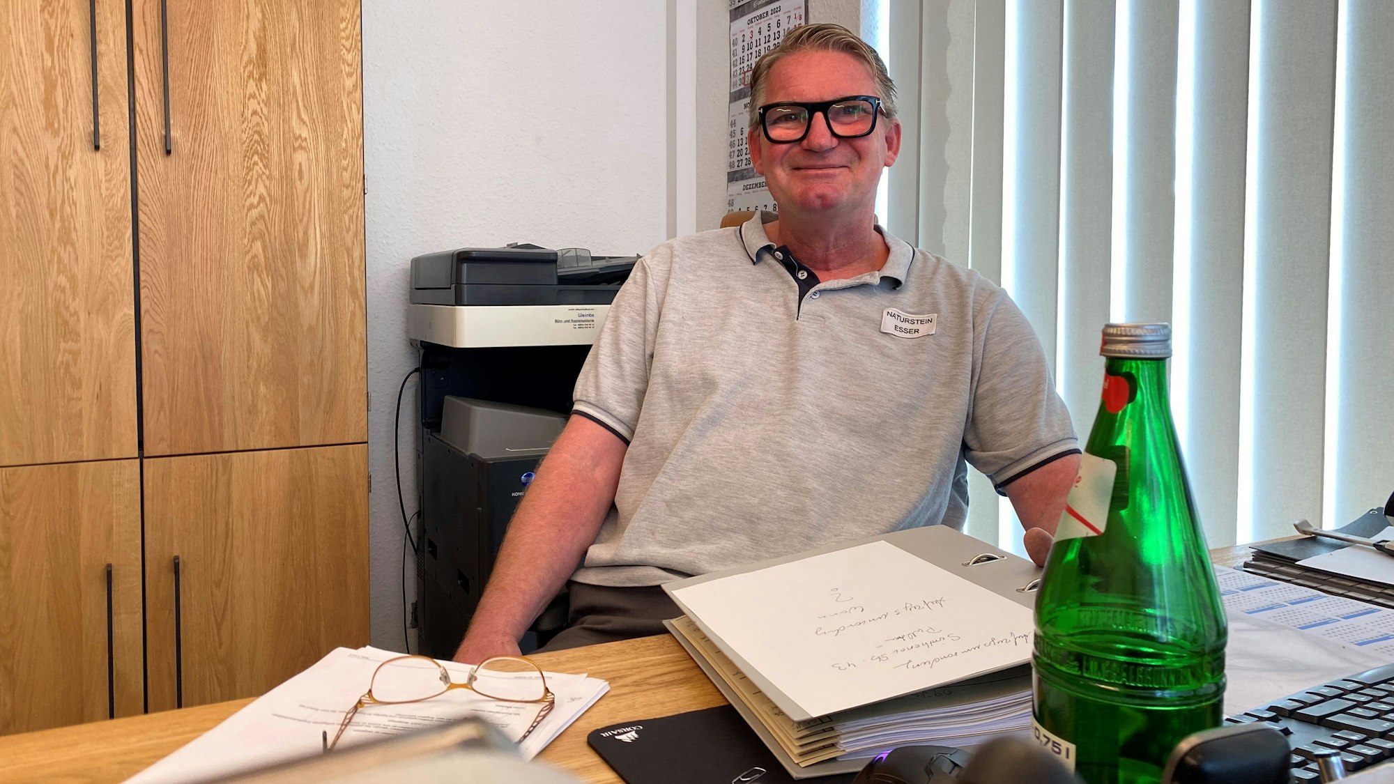 Der Steinmetz Rüdiger Essser sitzt im Büro seines Betriebes.