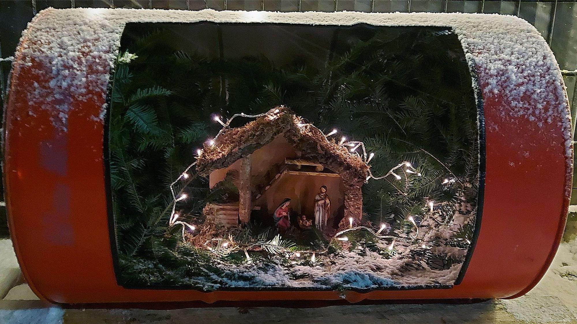 Ein altes Ölfass ist aufgeschnitten. Darin befindet sich nun eine Weihnachtskrippe.