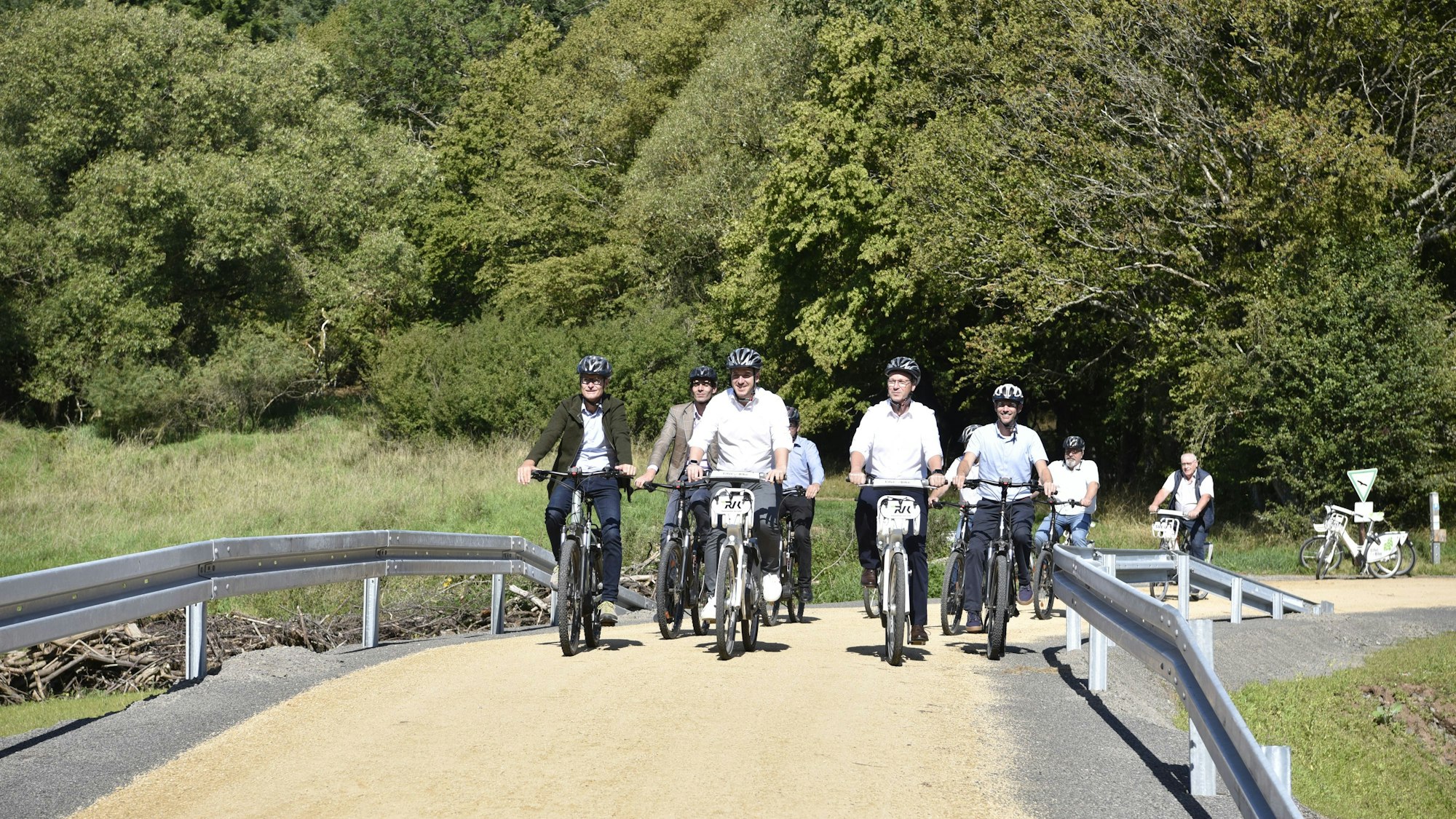 Mehrere Politiker fahren über den neuen Radweg.