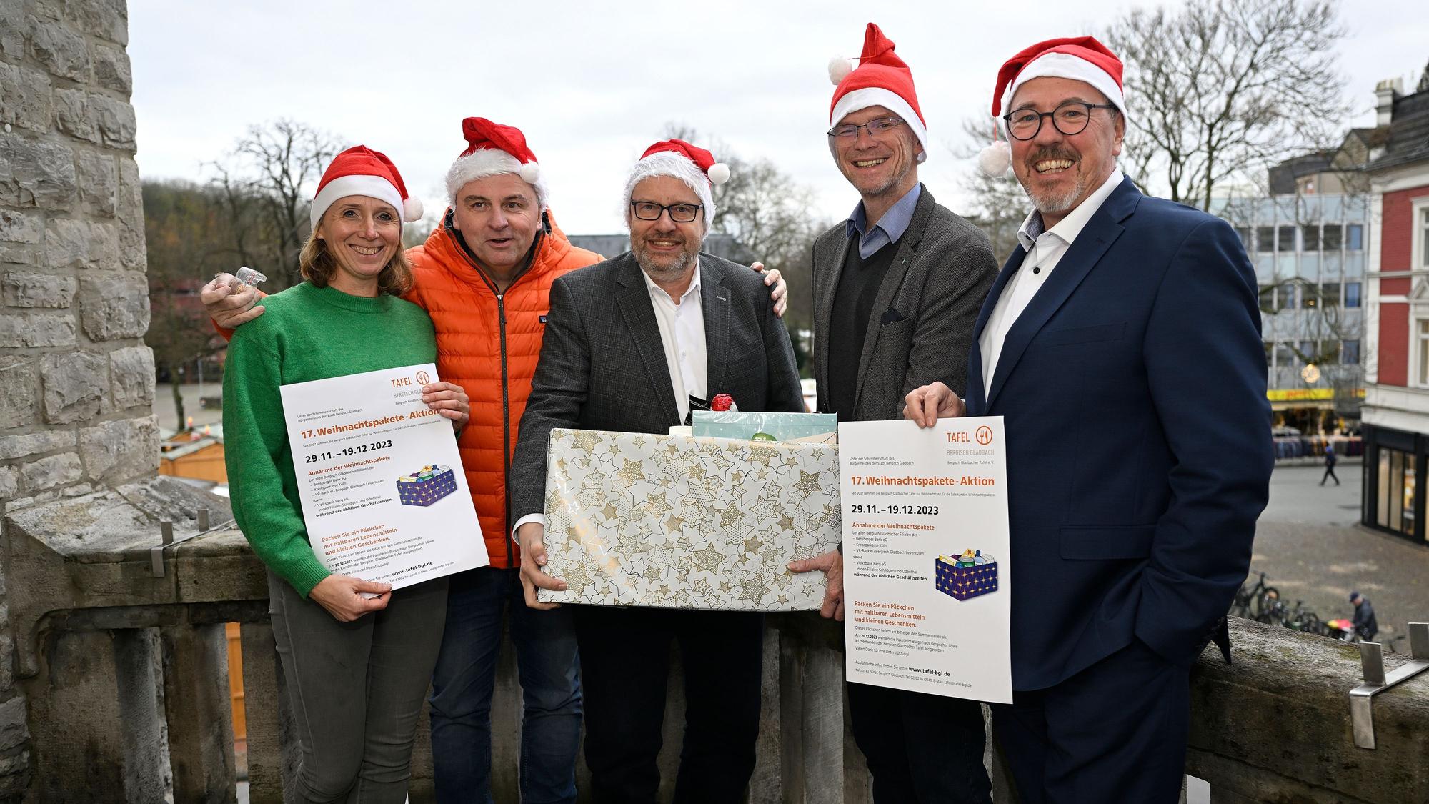 Freude im Karton: Die Gladbacher Tafel packt Weihnachtspakete, denen es finanziell nicht gut geht. Mit dabei Bürgermeister Frank Stein.
