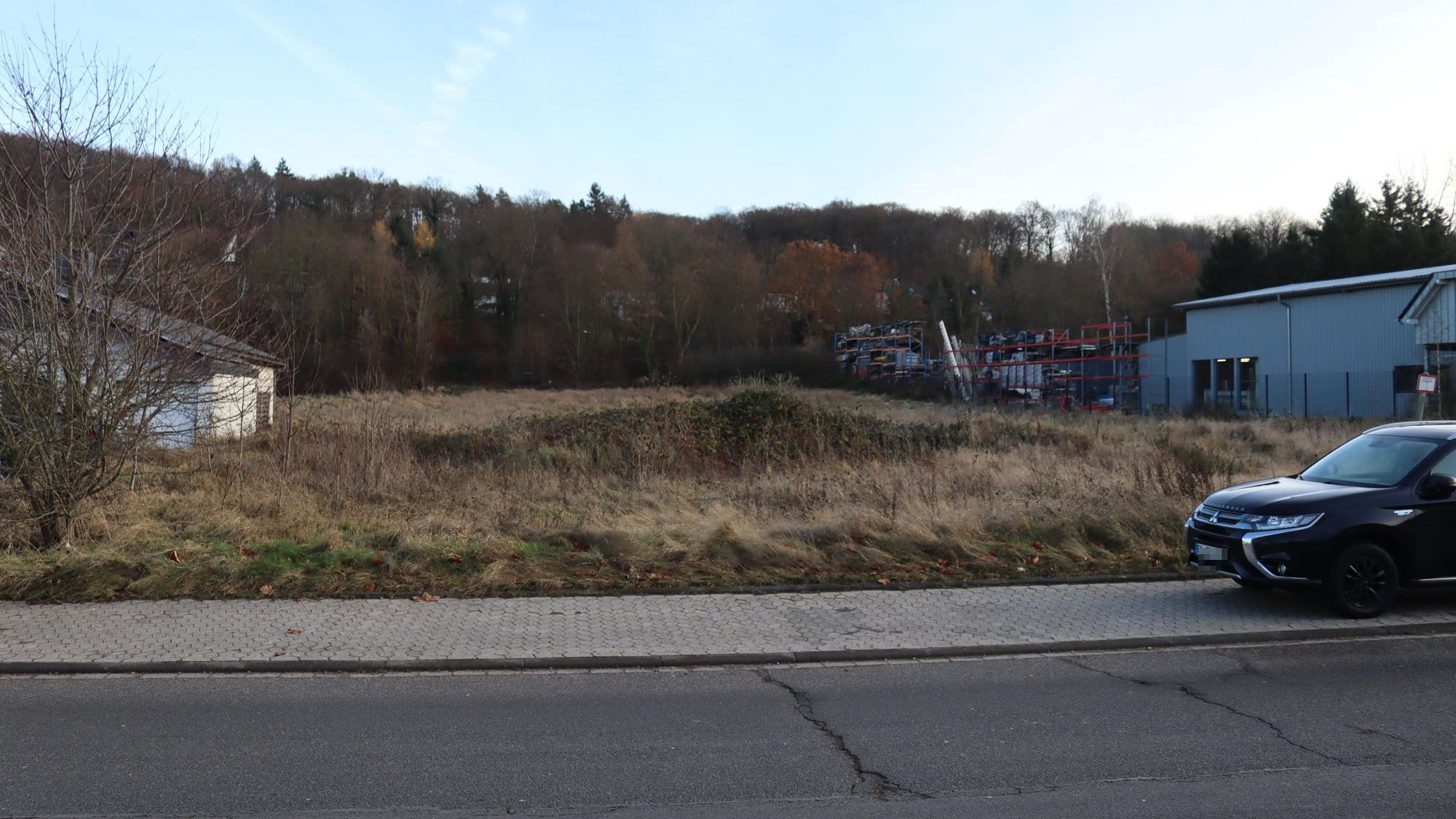 Eine freie Fläche, auf einem Parkstreifen steht ein Auto. Auf dem Grundstück sollen Container für Asylbewerber errichtet werden.