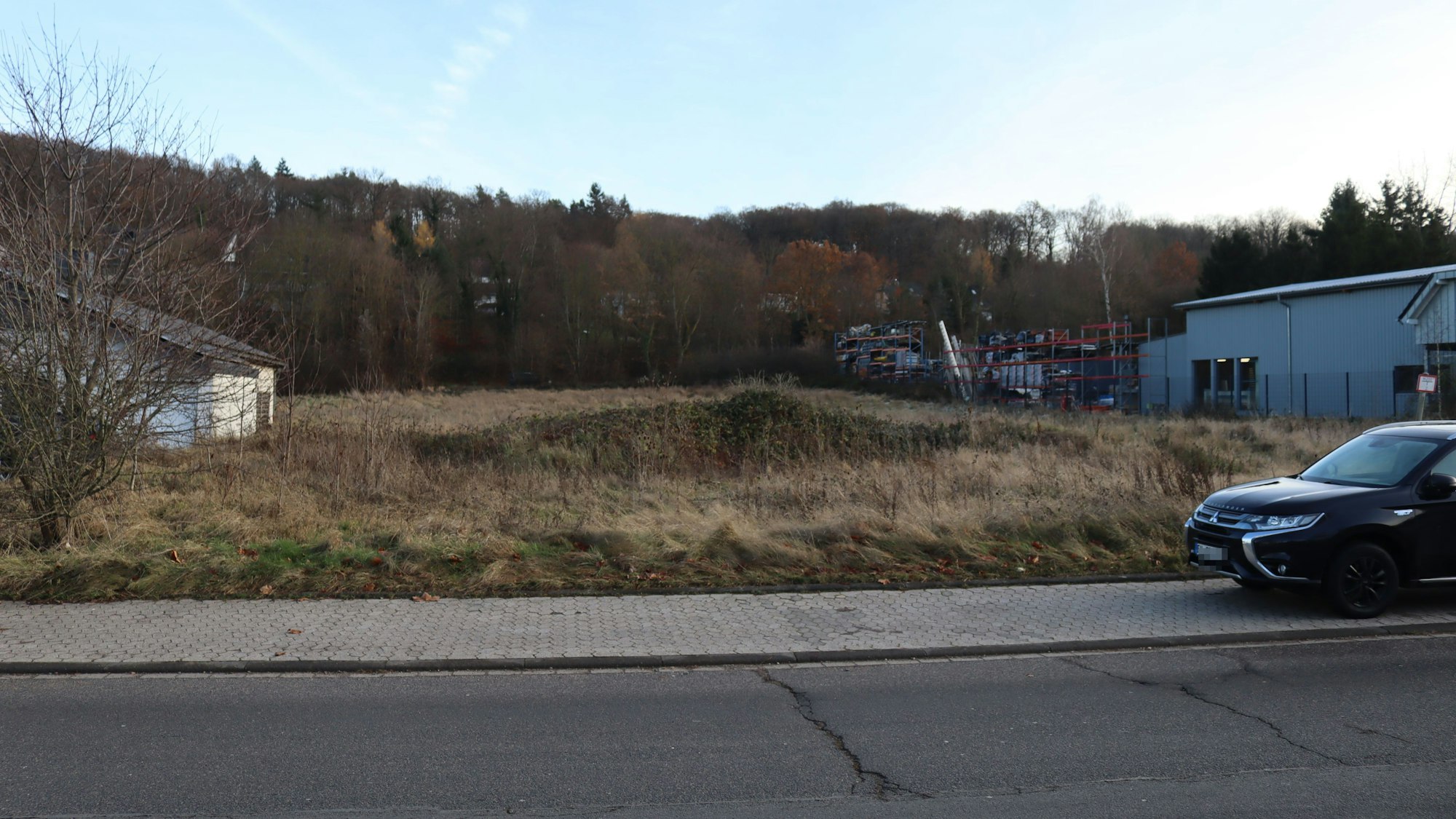 Eine freie Fläche, auf einem Parkstreifen steht ein Auto. Auf dem Grundstück sollen Container für Asylbewerber errichtet werden.
