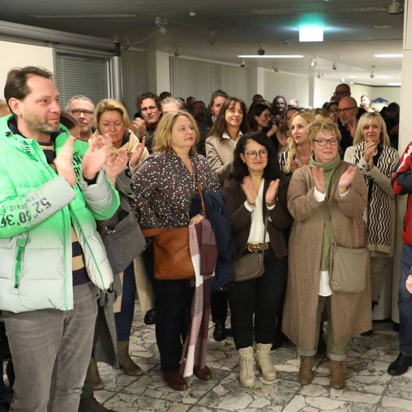 Kreisdirektor Dr. Erik Werdel steht im Foyer des Kreishauses Am Rübezahlwald. Menschen applaudieren ihm.