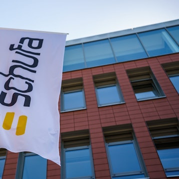 Eine Flagge mit dem Firmenlogo flattert vor dem Geschäftssitz in der Landeshauptstadt.