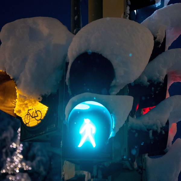 Schnee liegt auf einer Ampel an einer Kreuzung.
