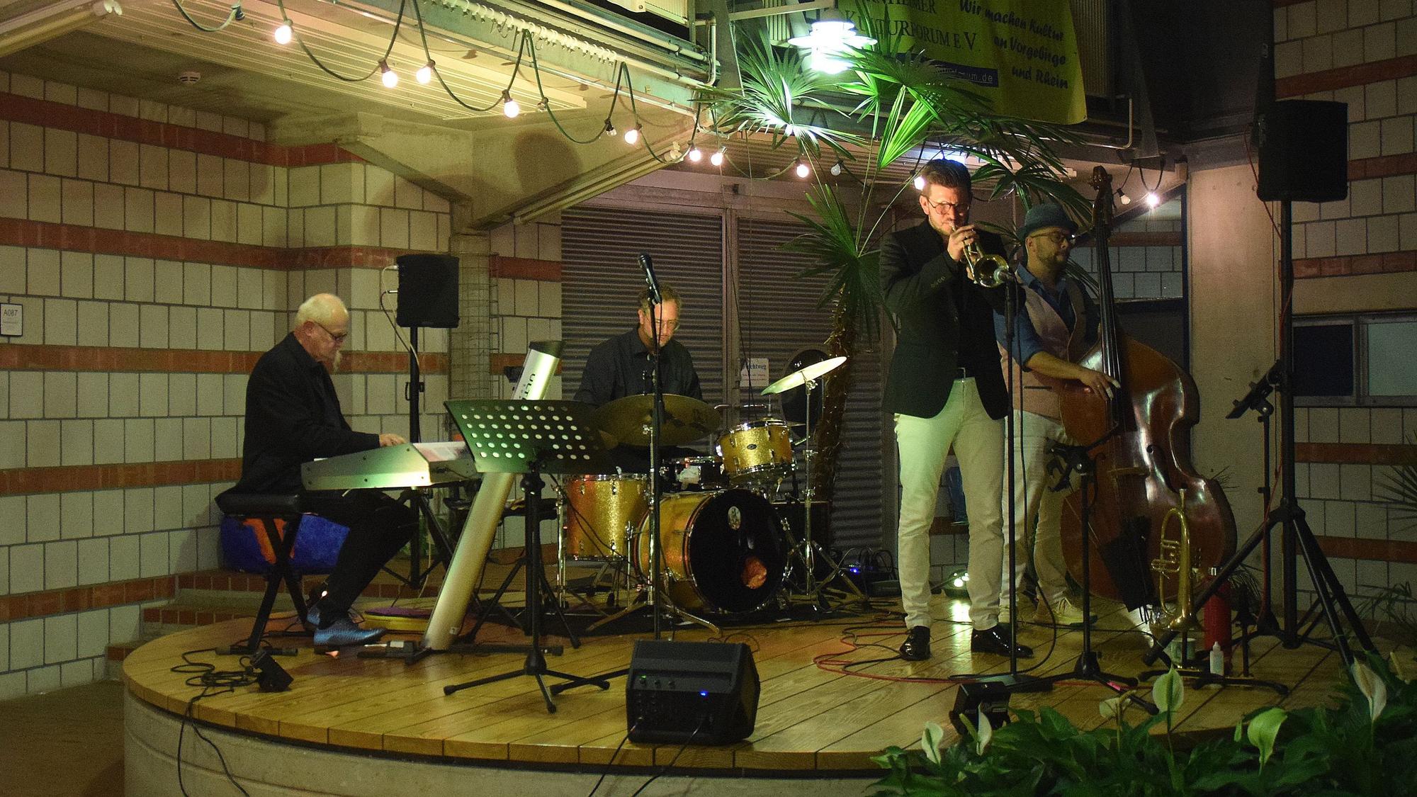 Blick auf die Bühne bei der Veranstaltung „Jazz und Wein“ in der Europaschule Bornheim: Der Trompeter Michael Kuhl spielt gemeinsam mit anderen Musikern.