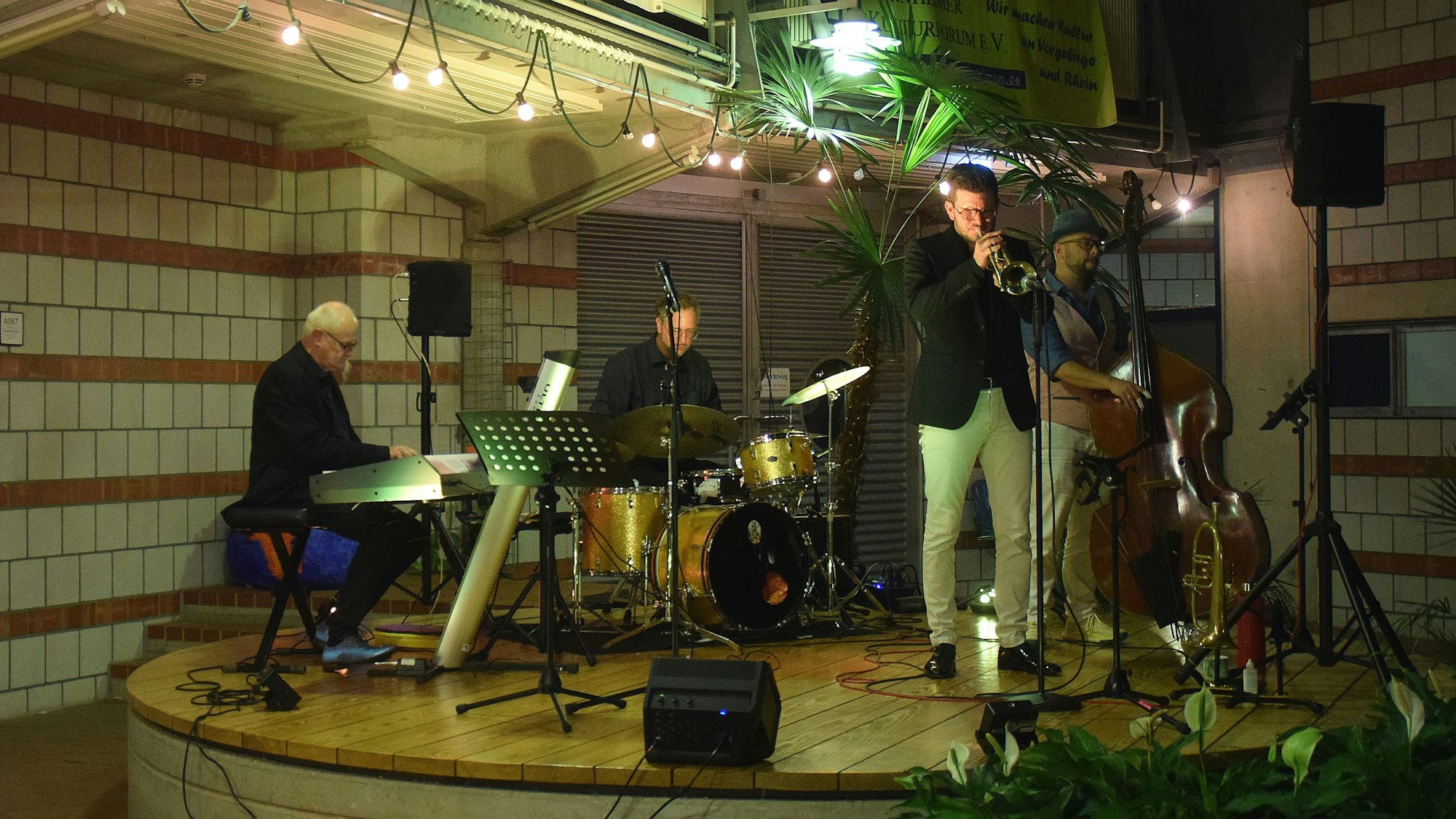 Blick auf die Bühne bei der Veranstaltung „Jazz und Wein“ in der Europaschule Bornheim: Der Trompeter Michael Kuhl spielt gemeinsam mit anderen Musikern.