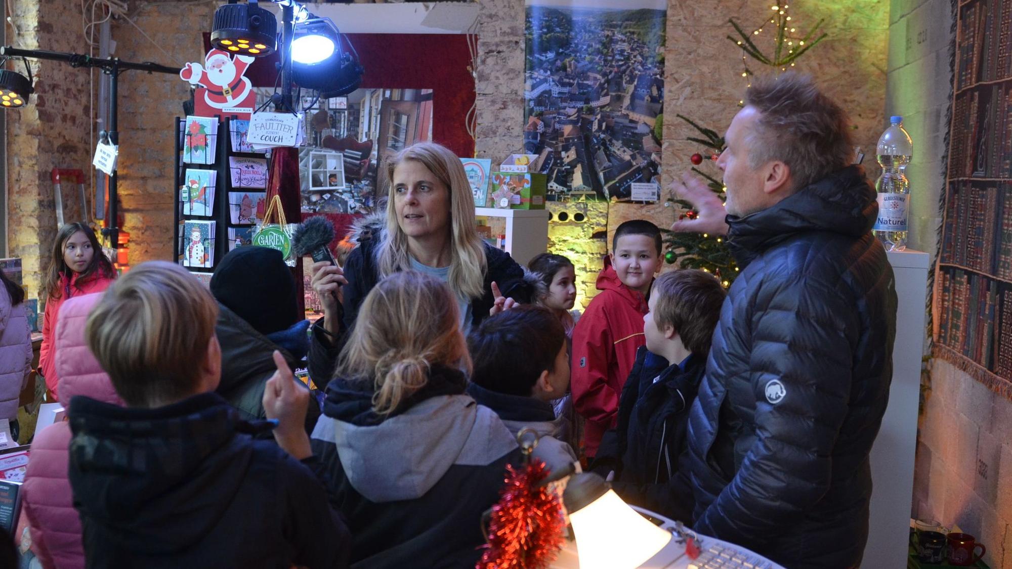 Kinder und Erwachsene tummeln sich in der weihnachtlich dekorierten Buchhandlung Mütters.
