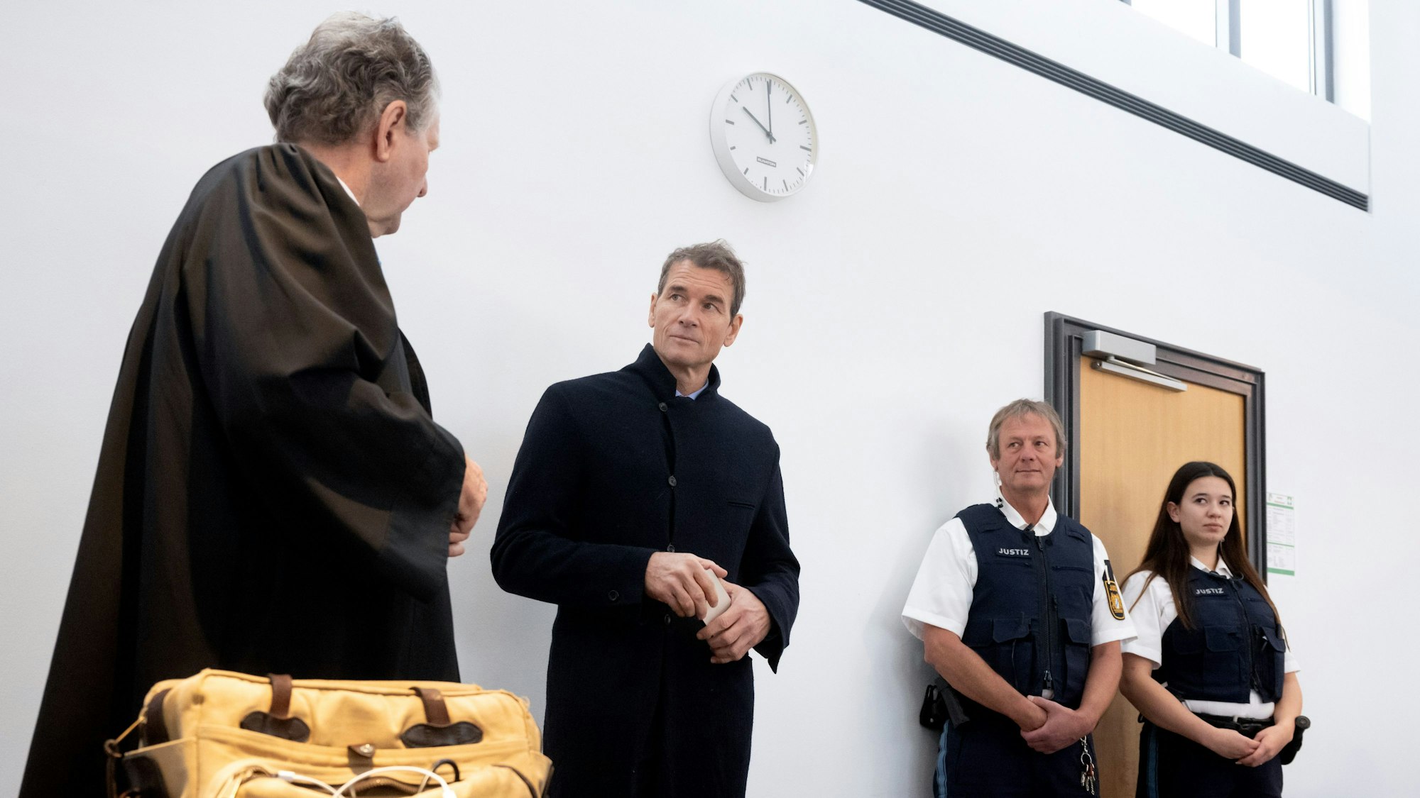 Der wegen Hausfriedensbruch und Sachbeschädigung angeklagte ehemalige Nationaltorwart Jens Lehmann (2.v.l.) steht vor Prozessbeginn mit seinem Anwalt Christoph Rückel (l) im Amtsgericht im Gerichtssaal.