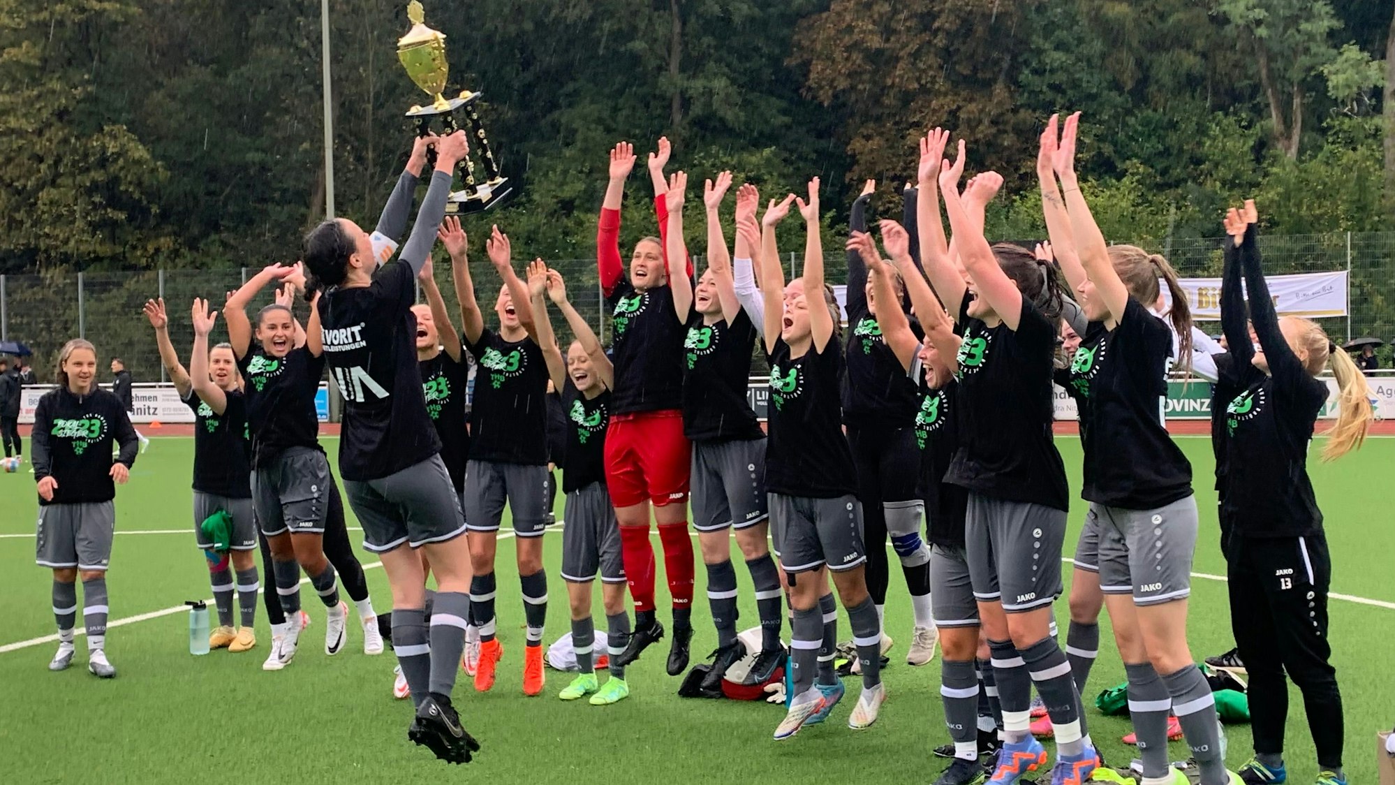 Nach dem Gewinn des Kreispokals feiern die Fußballerinnen des TuS Homburg-Bröltal springend mit dem Pokal.